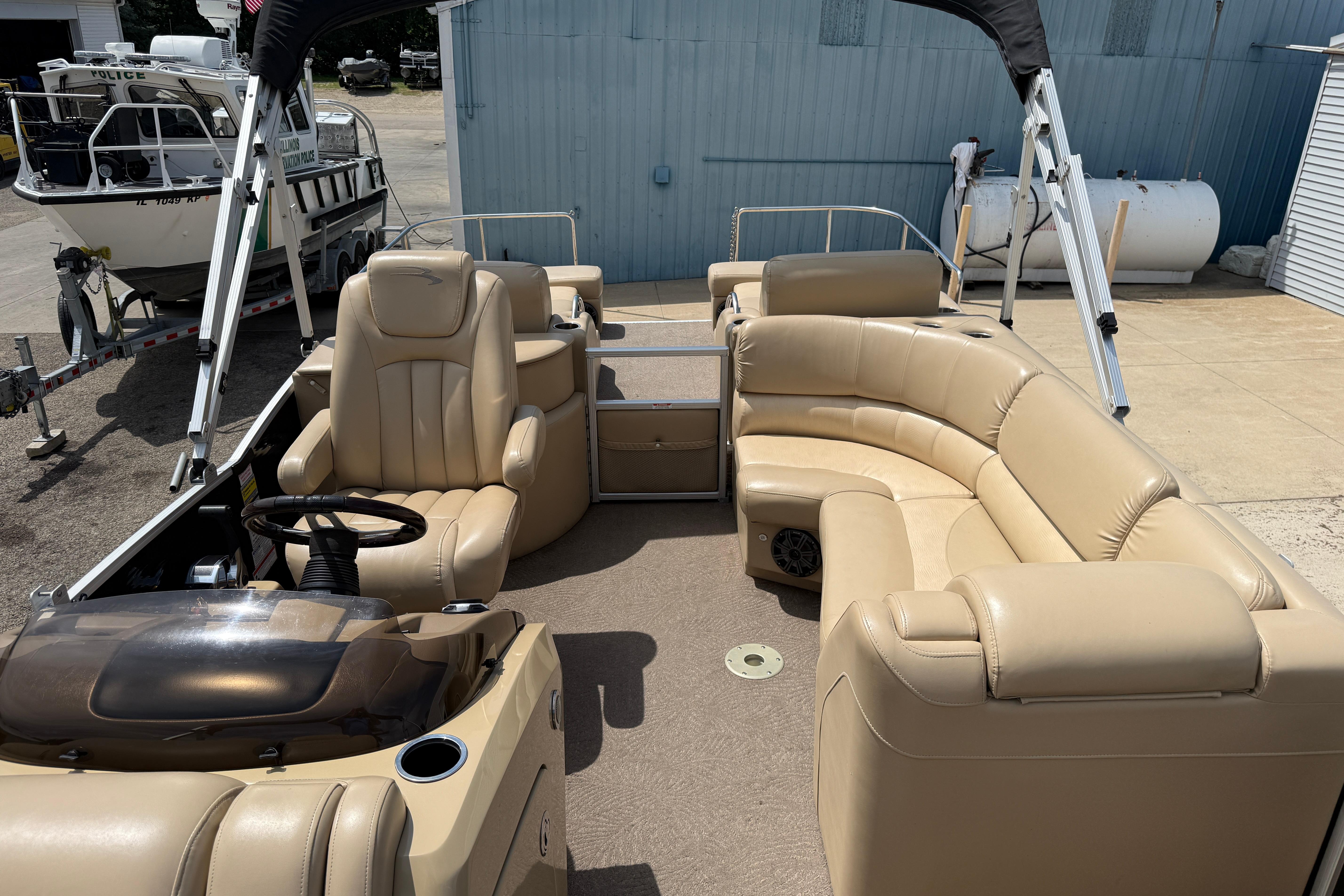 2011 Bennington 2575QCW I/O pontoon boat with beige seating and steering console.