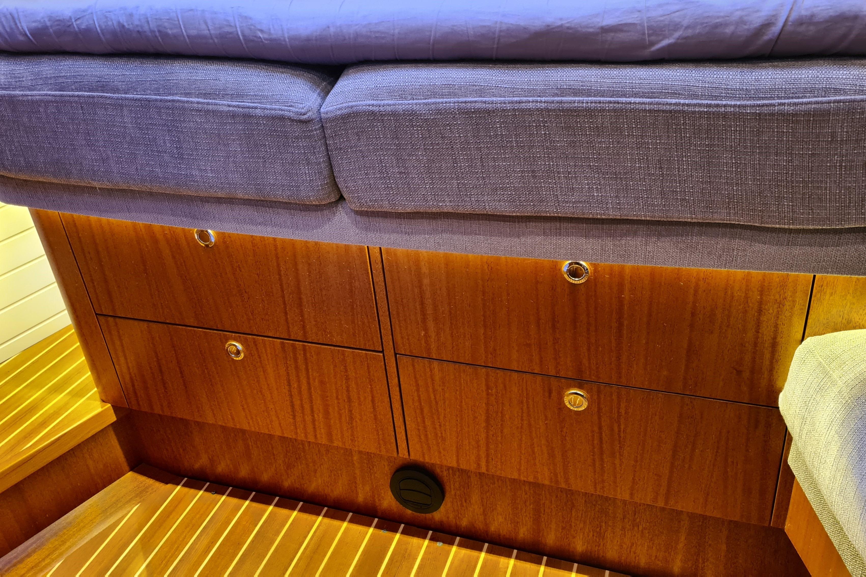 Interior of 2018 Arcona 435 yacht with wooden drawers and cushioned seating.