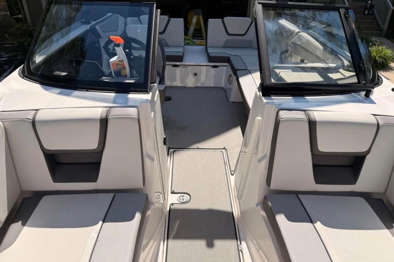 2024 Yamaha Boats AR220 interior with seating and windshield, showcasing modern design.