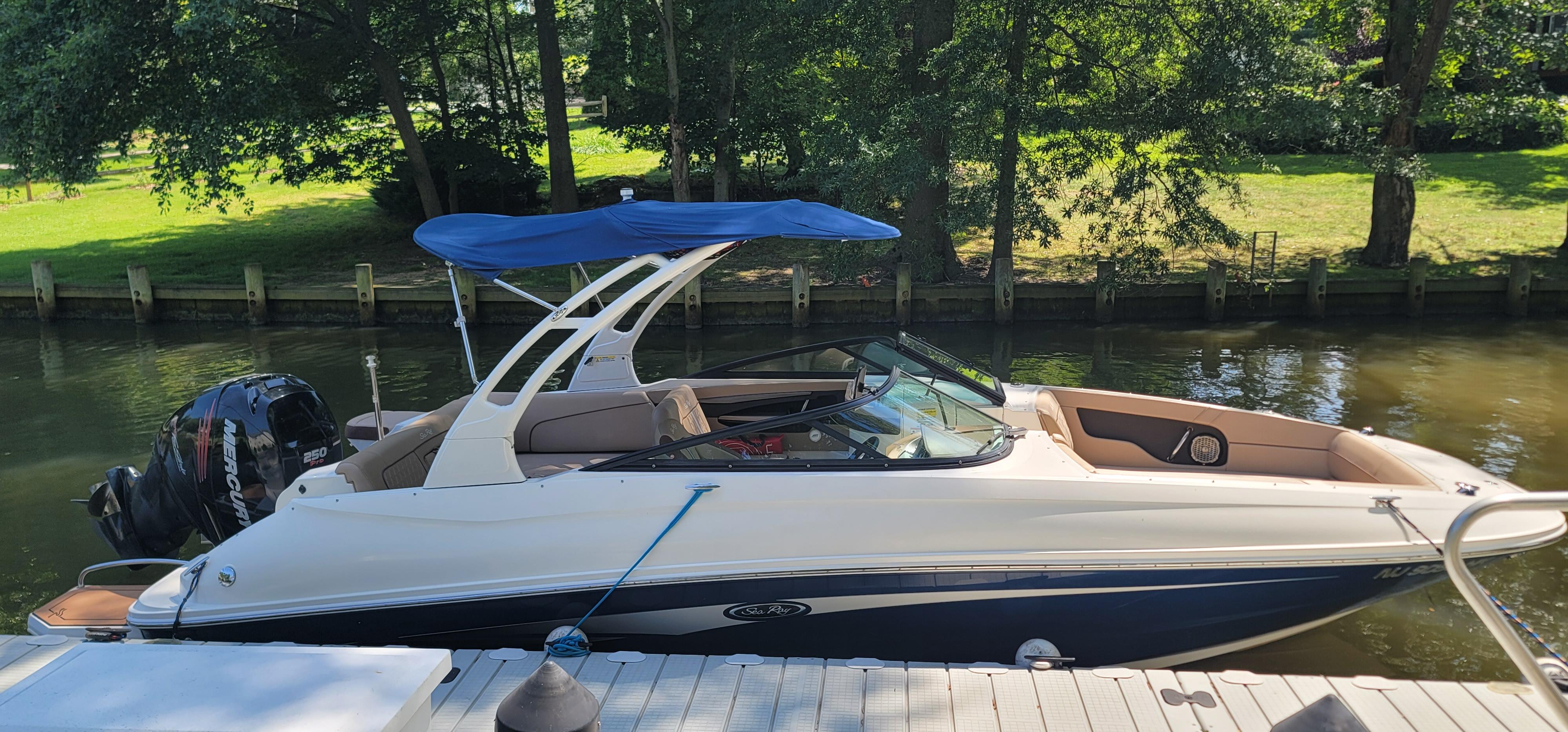 2017 Sea Ray SDX 240 Outboard boat docked by a serene riverside.