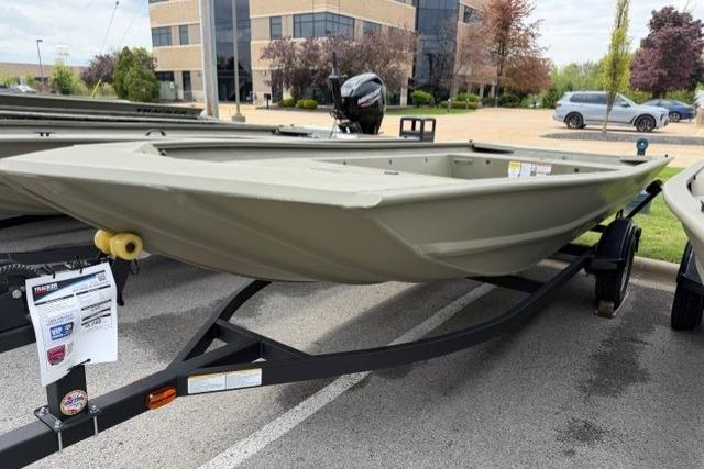2025 Tracker Grizzly 1754 Jon boat on trailer, parked outdoors near office building.