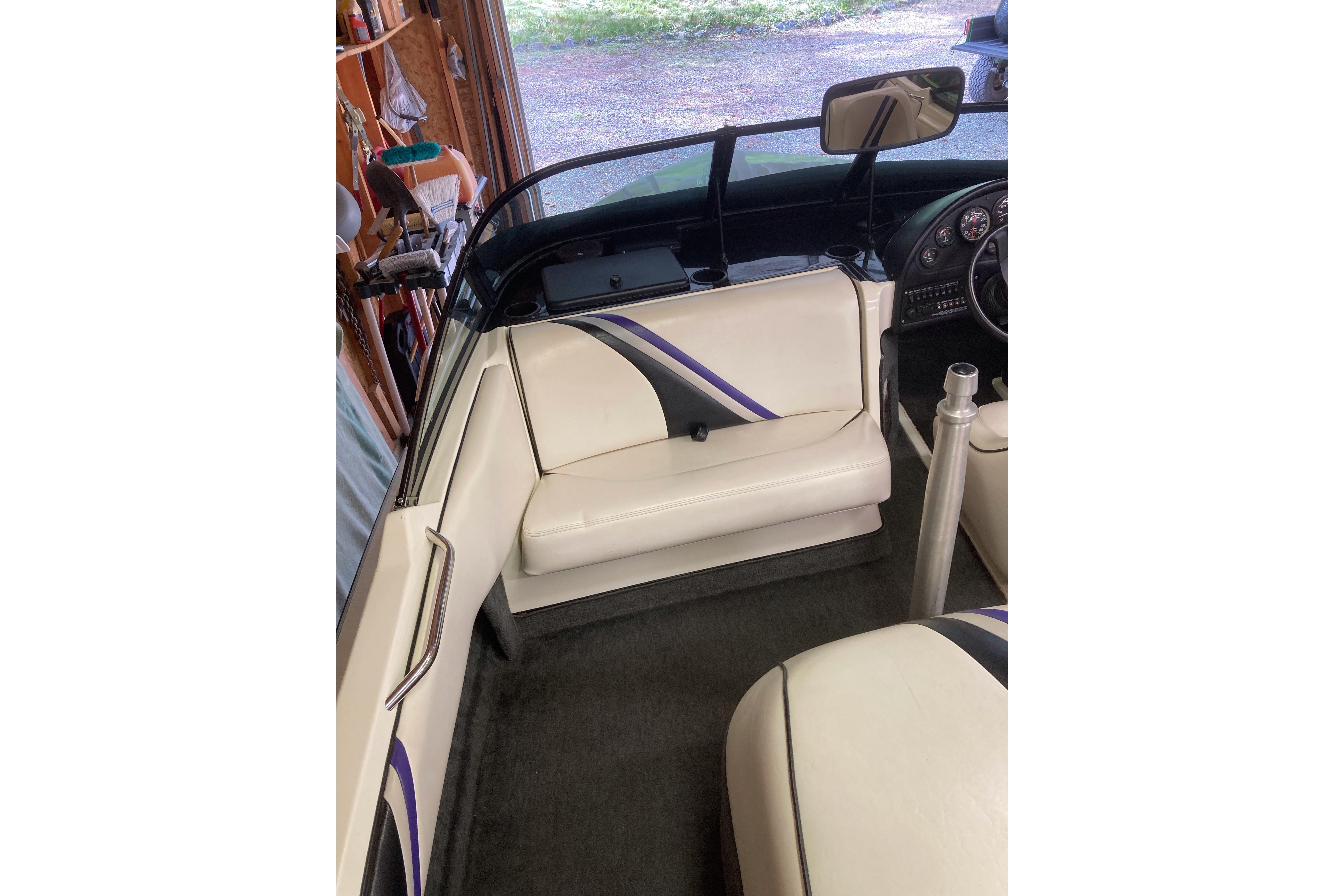 1996 Malibu Response boat interior with white and purple seating in a garage setting.