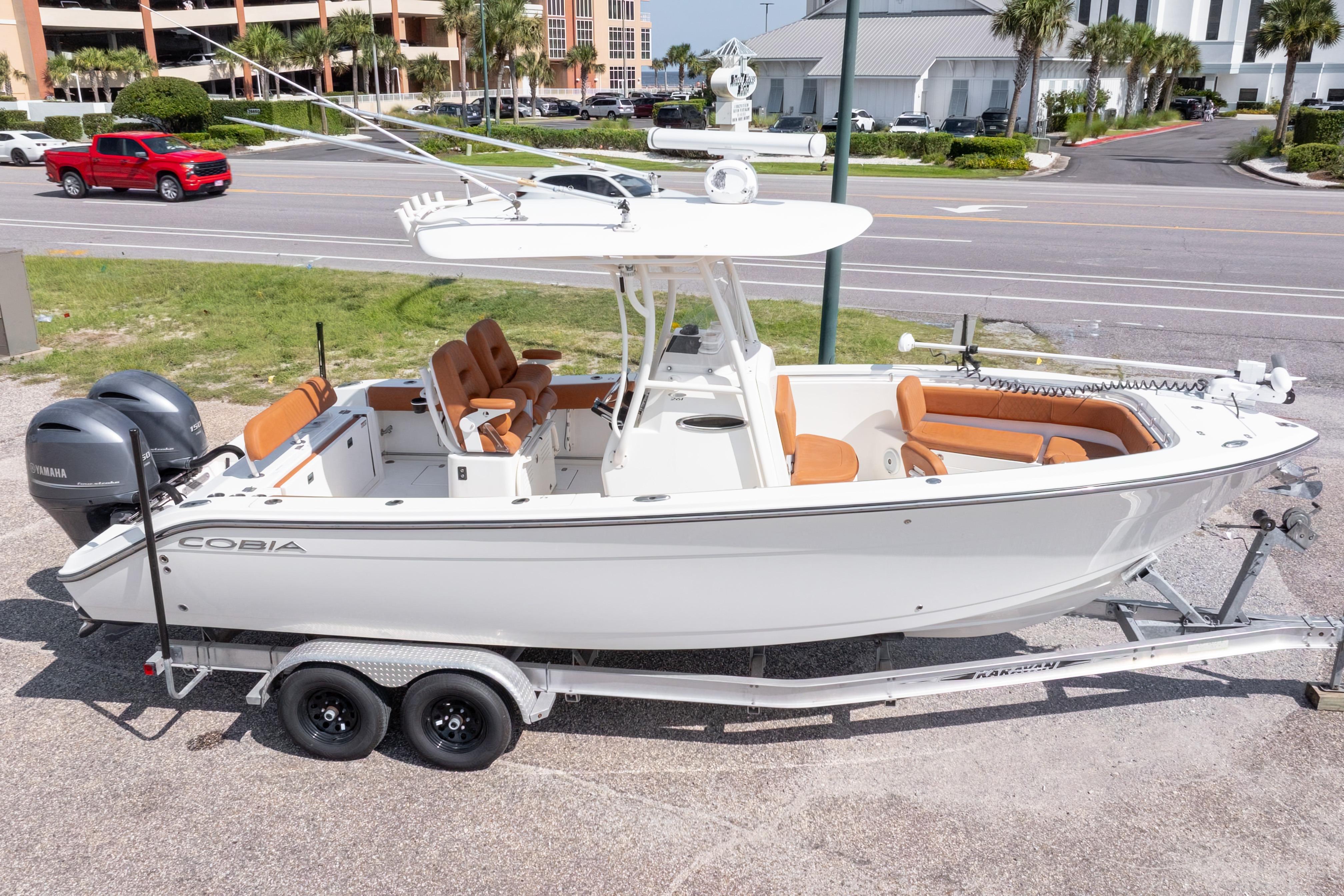 2017 Cobia 261 Center Console boat on trailer, parked near road.