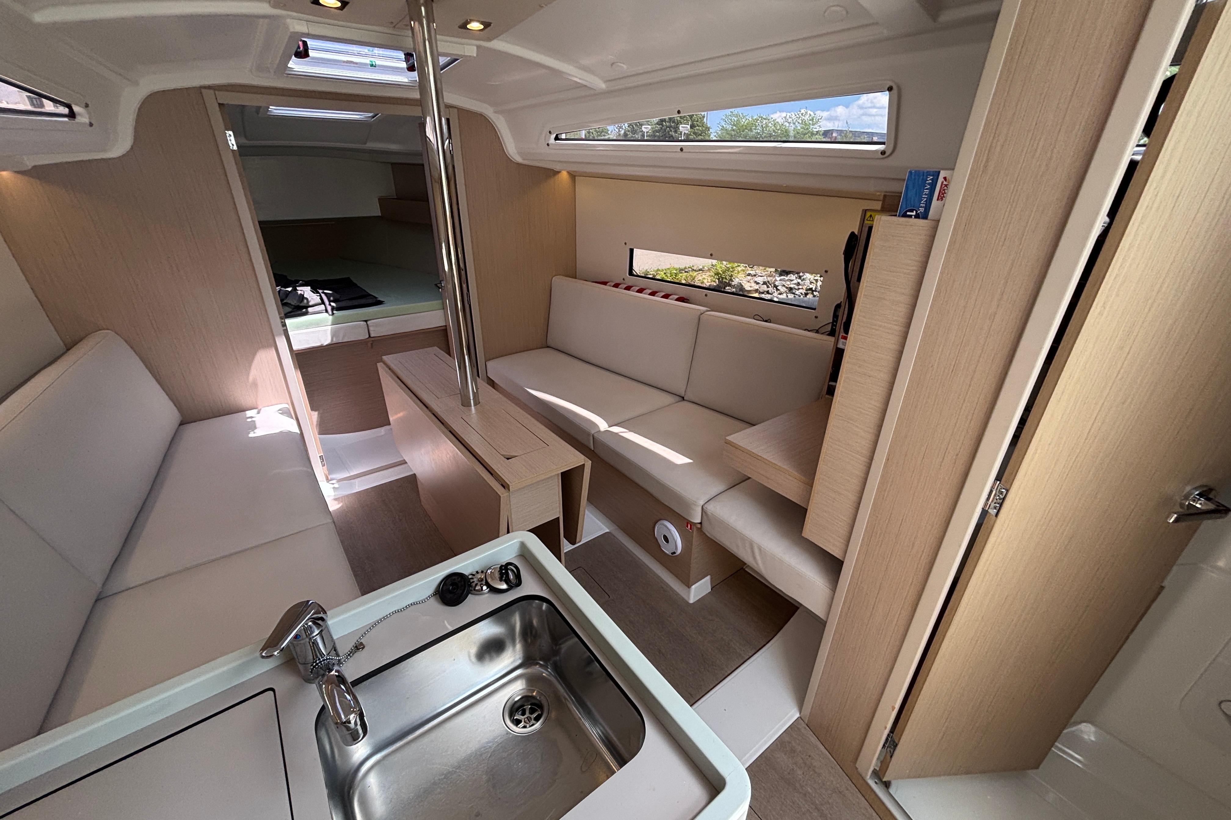 Interior of 2021 Beneteau Oceanis 30.1 yacht, featuring modern seating and kitchenette.