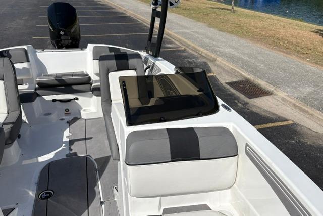 2024 Tahoe T21 boat interior with gray and white seating, parked near water.