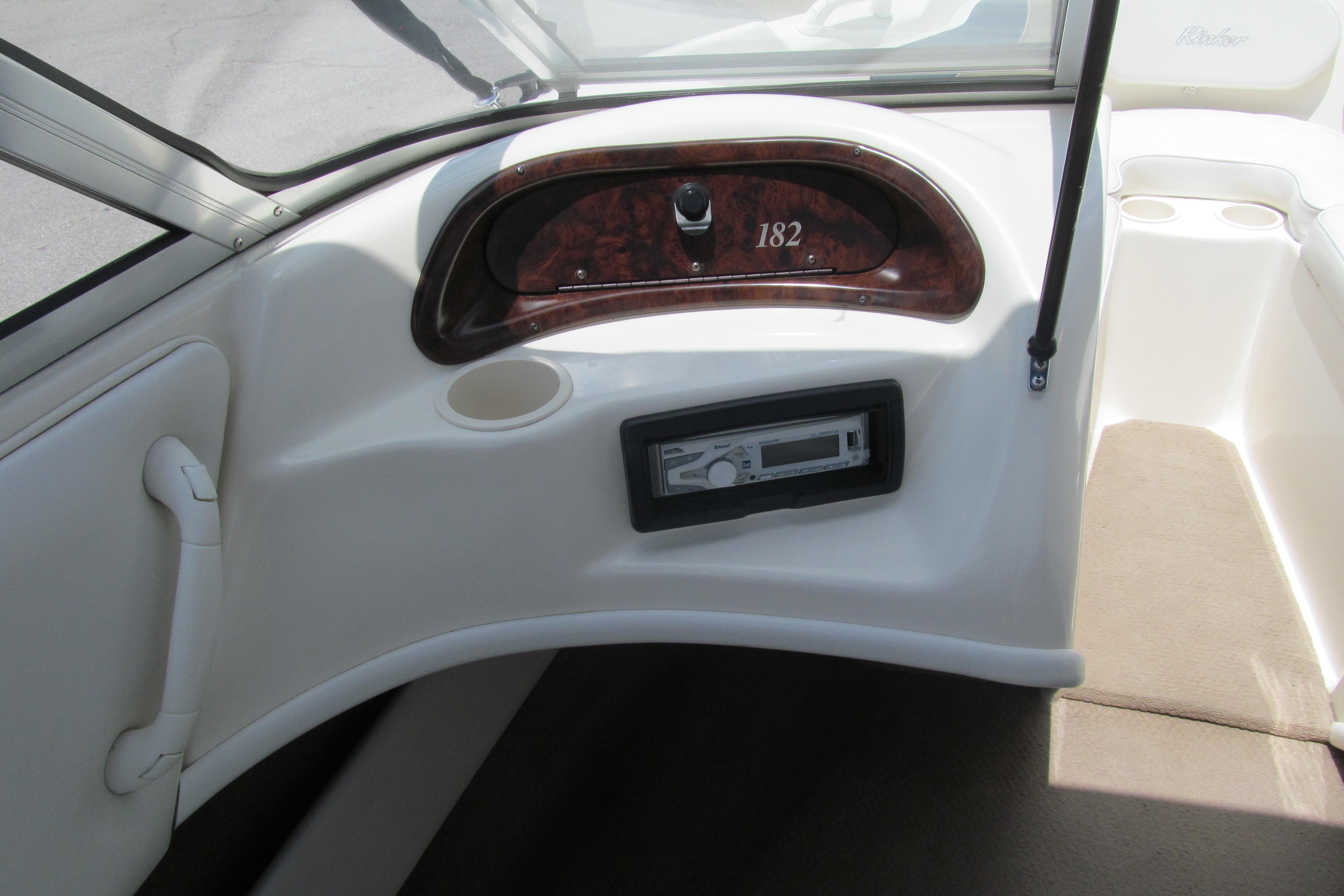 2000 Rinker boat dashboard with speedometer and stereo system, featuring beige interior.