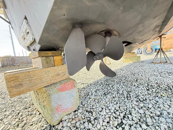 Propeller of 2001 Albemarle 280 Express Sport Fisherman on dry dock, supported by wooden blocks.