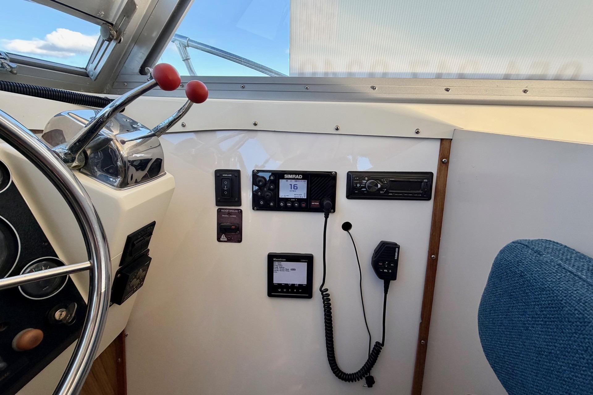 Interior helm of 1981 Bertram 28 Flybridge Cruiser with navigation equipment and controls.