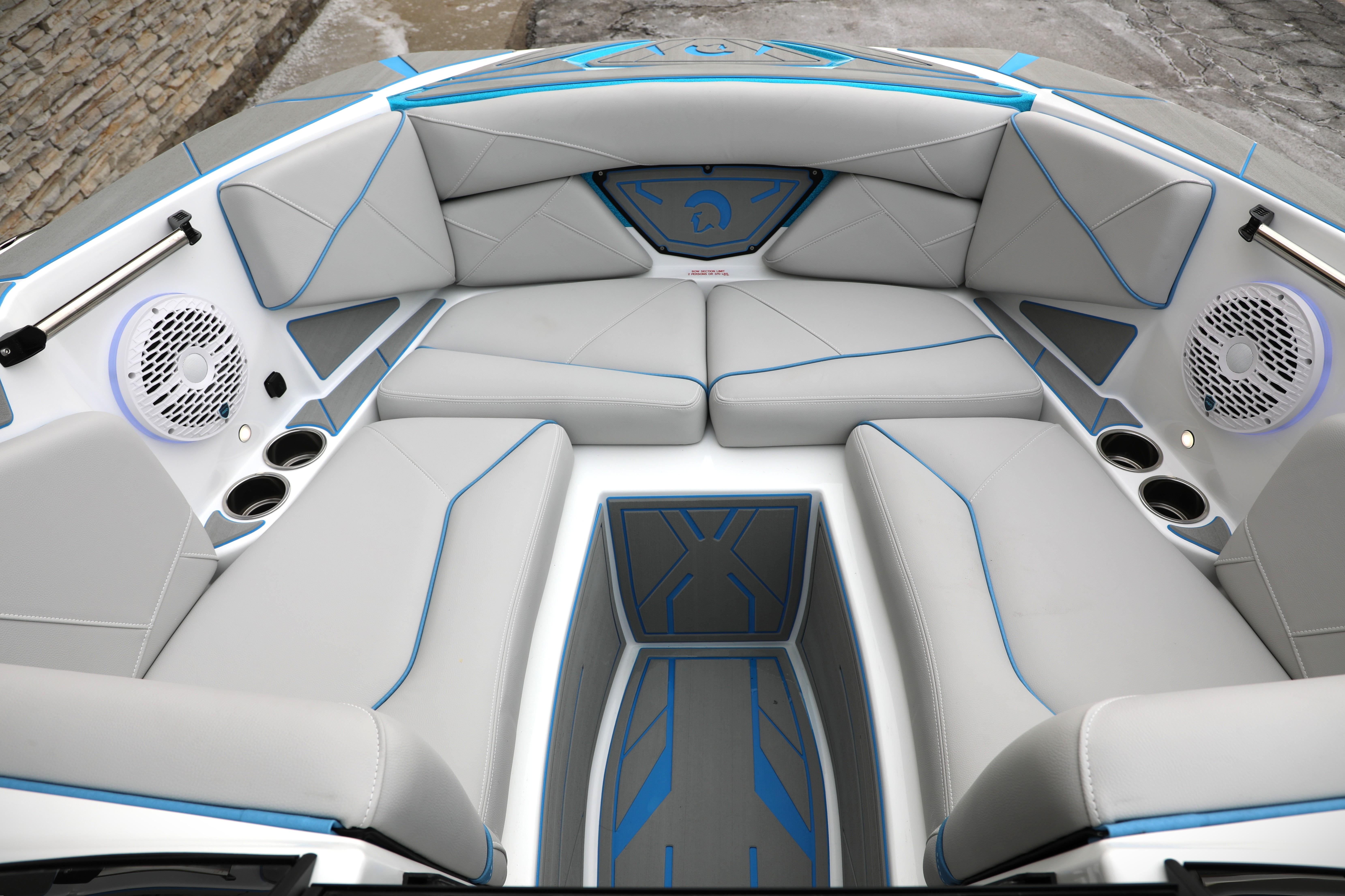 Luxurious interior of 2026 Centurion Nv233 boat with sleek gray seating and blue accents.