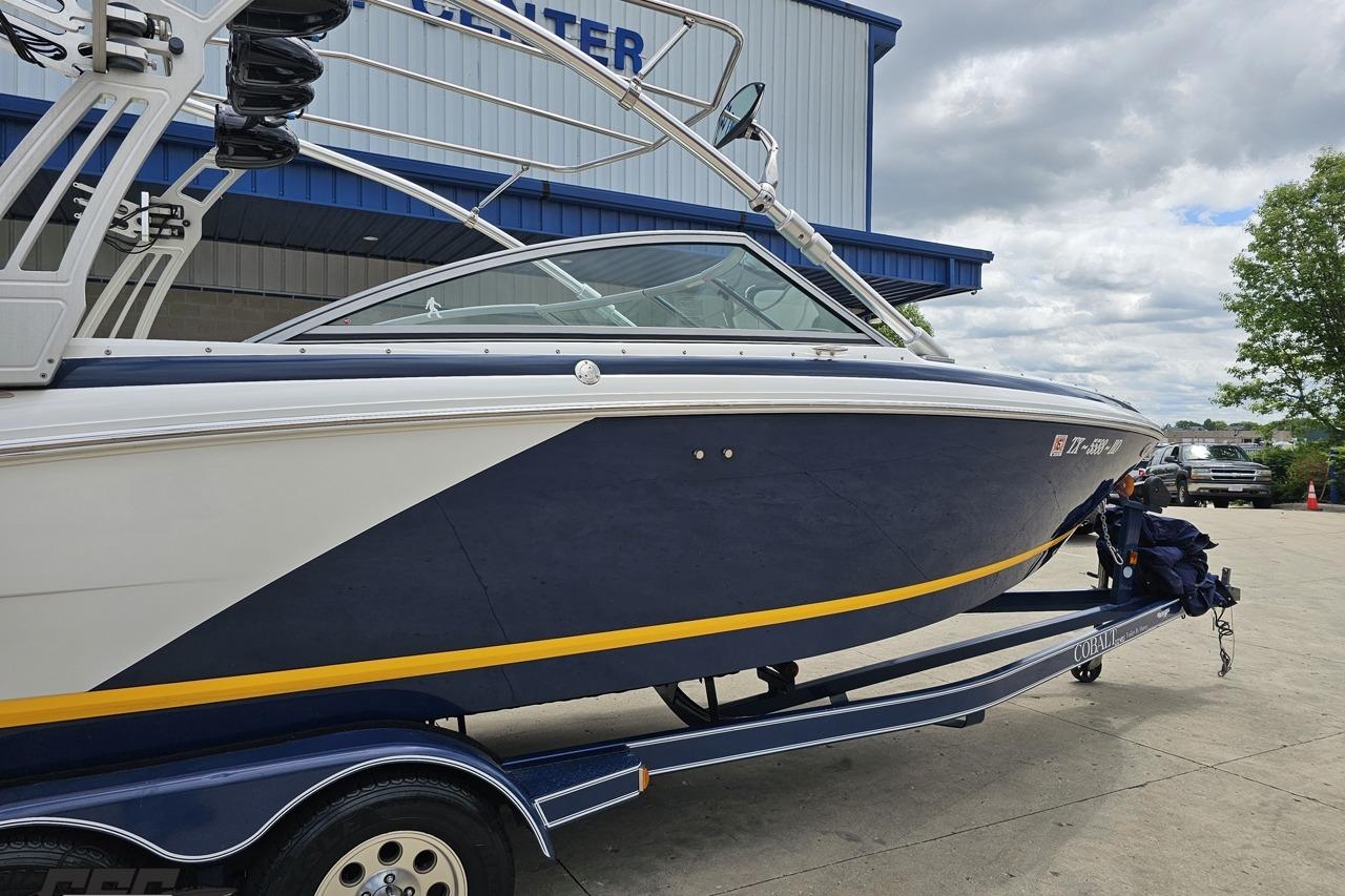 2010 Cobalt 232 WSS boat on trailer, parked outdoors near a building.