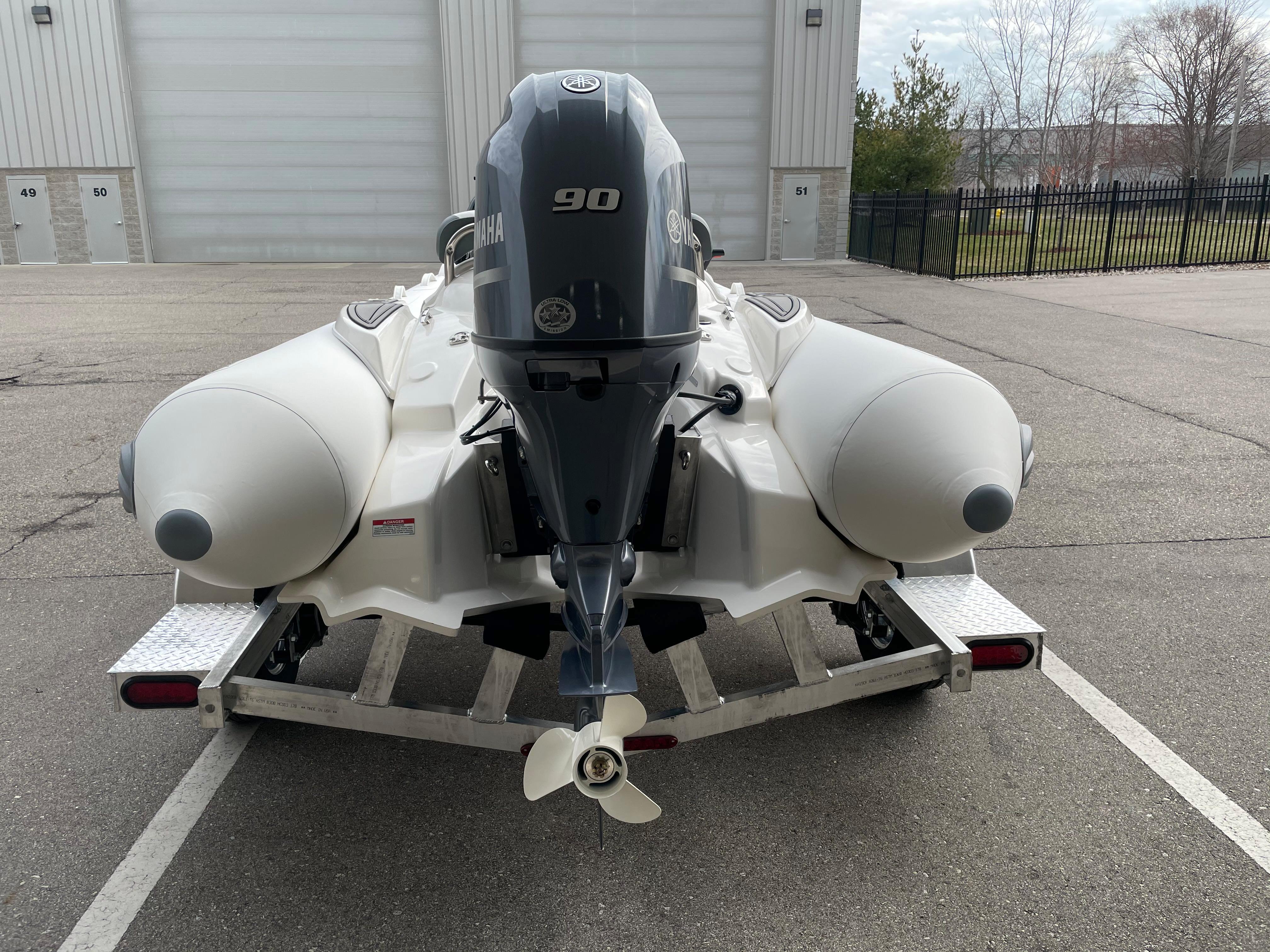 2023 Zodiac Yachtline 490 Deluxe NEO 90hp on trailer, rear view.