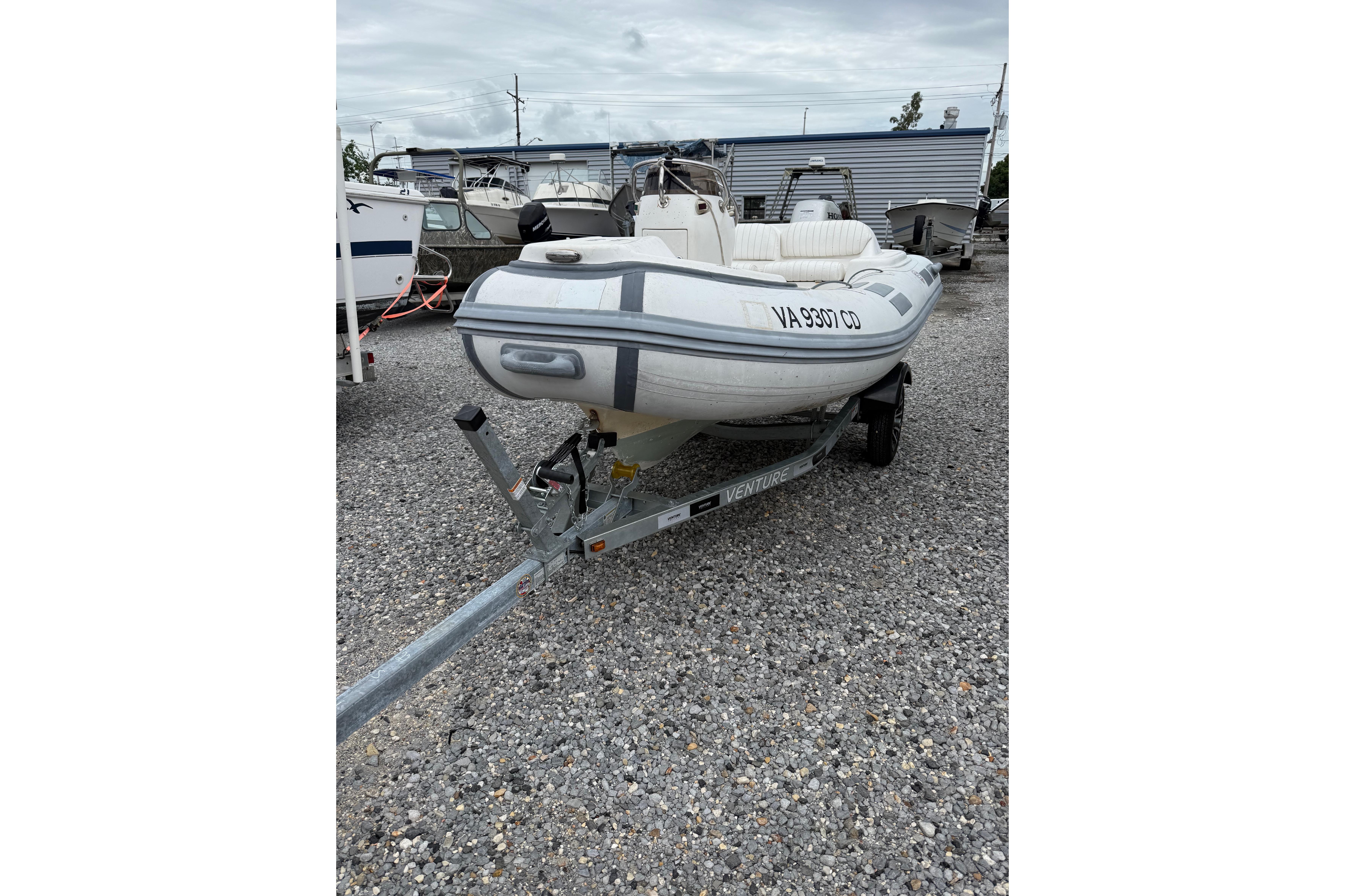 2008 Caribe DL-11 inflatable boat on trailer in a gravel lot.