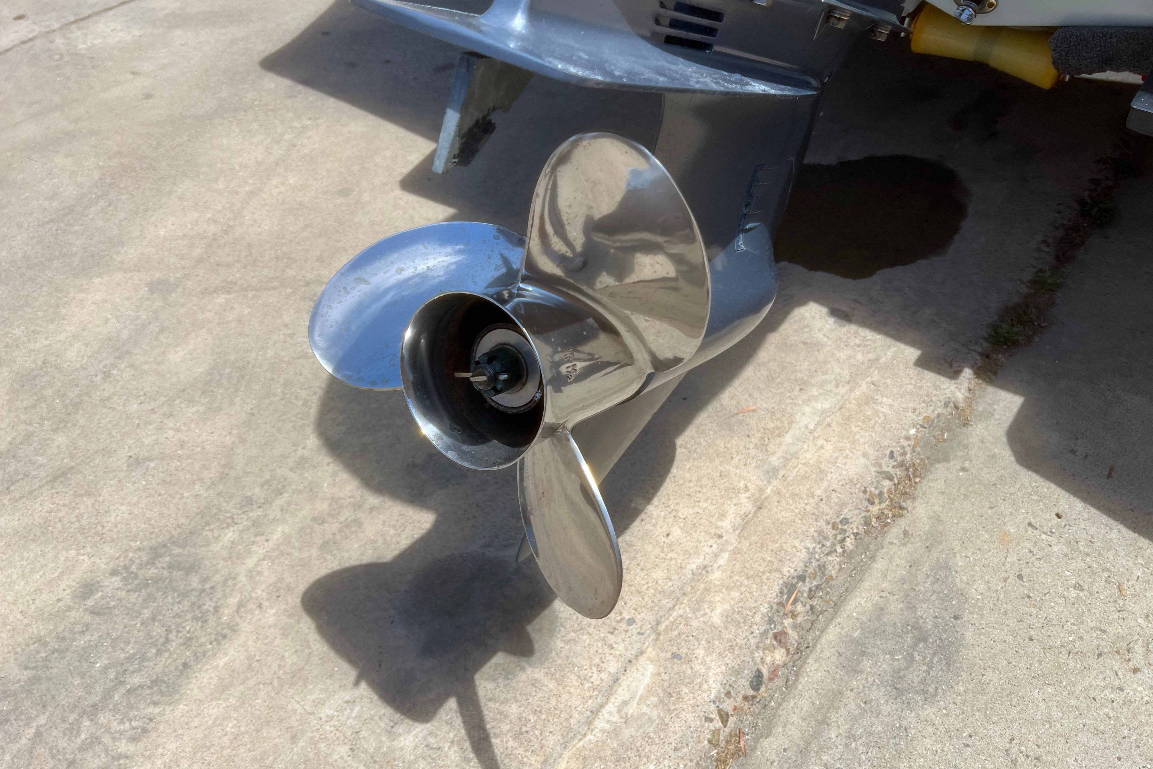 Propeller of a 2018 Cobia 201 Center Console boat on concrete surface.