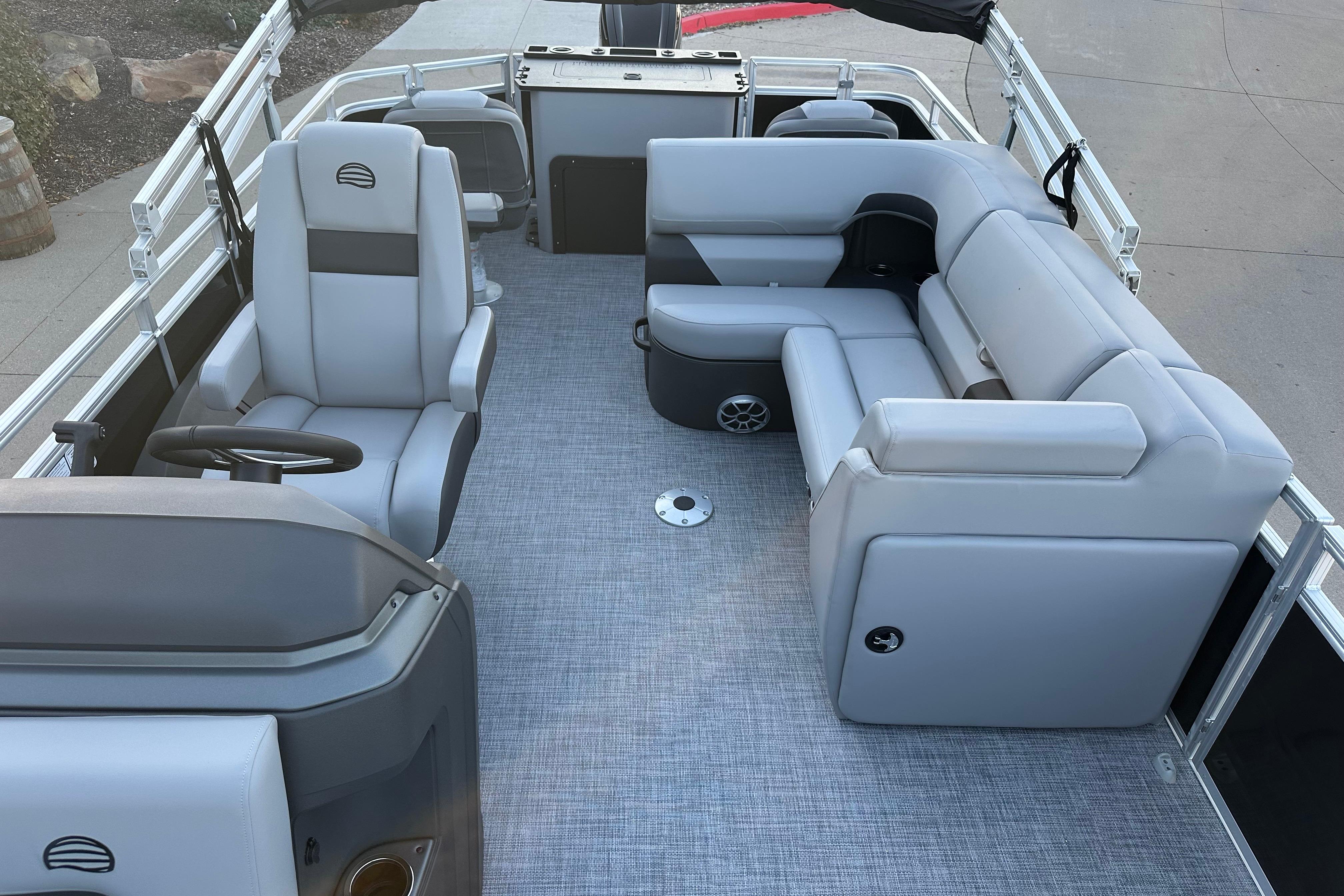 2026 Sun Tracker SportFish 22 DLX pontoon boat interior with gray seating and steering console.