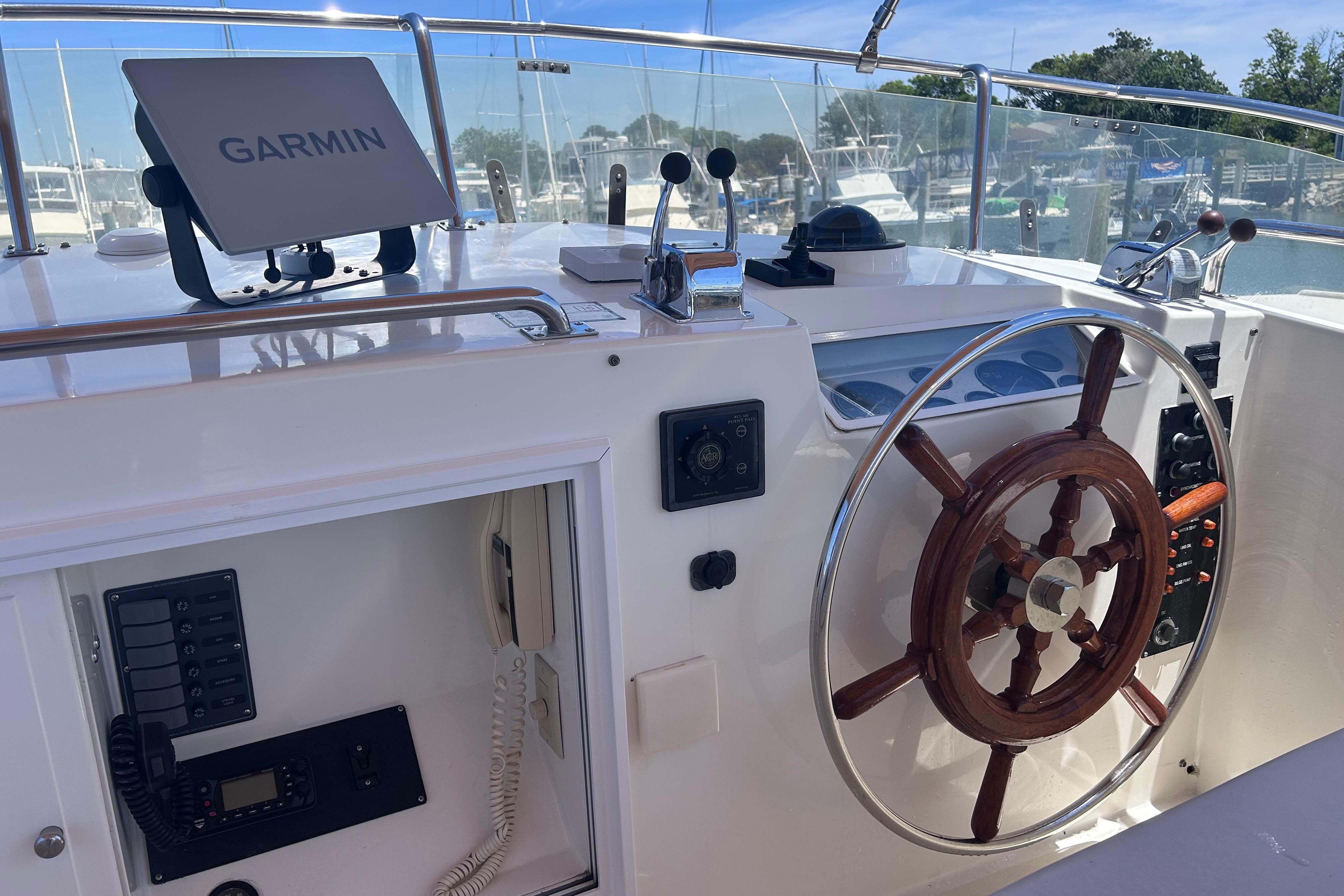 Helm of 1999 Grand Banks 42 Europa with Garmin navigation system and wooden steering wheel.