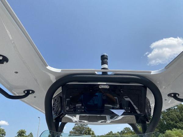 2021 Scarab 255 Open ID boat with T-top and electronics, clear sky background.