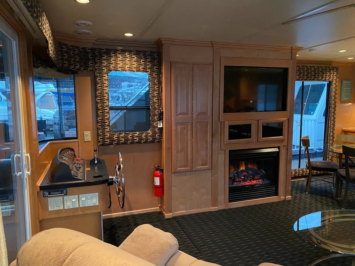 Interior of a 2006 Summersun Houseboat with fireplace and TV.