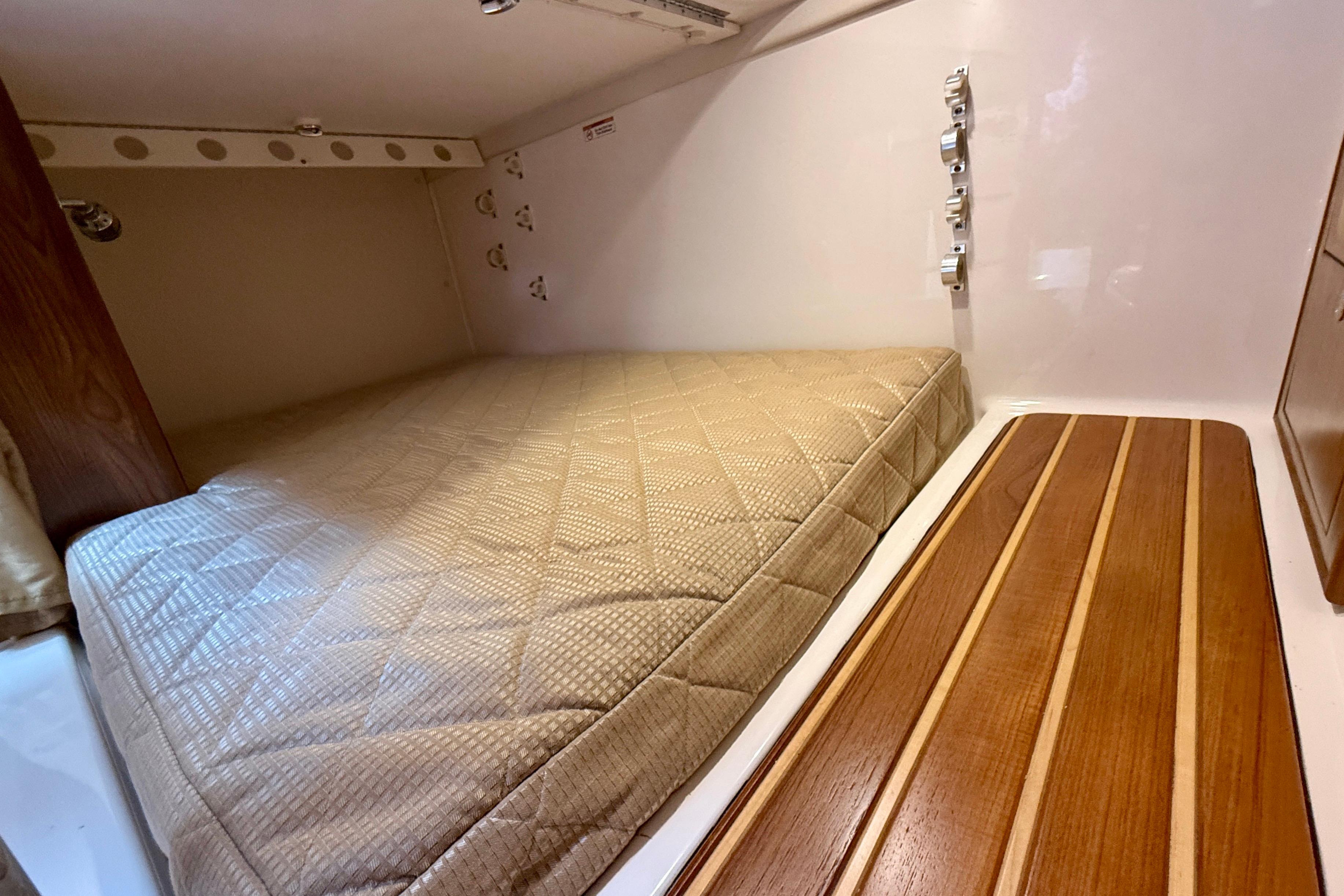 2012 Pursuit OS 345 Offshore cabin interior with bed and wooden accents.