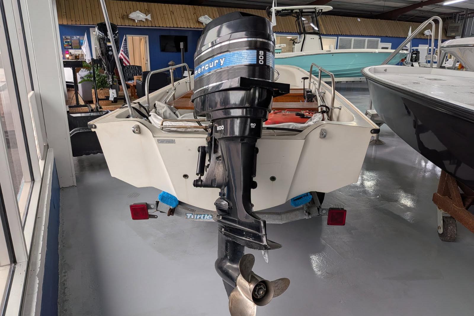 1978 Boston Whaler 15 SPORT boat with Mercury outboard motor in showroom.
