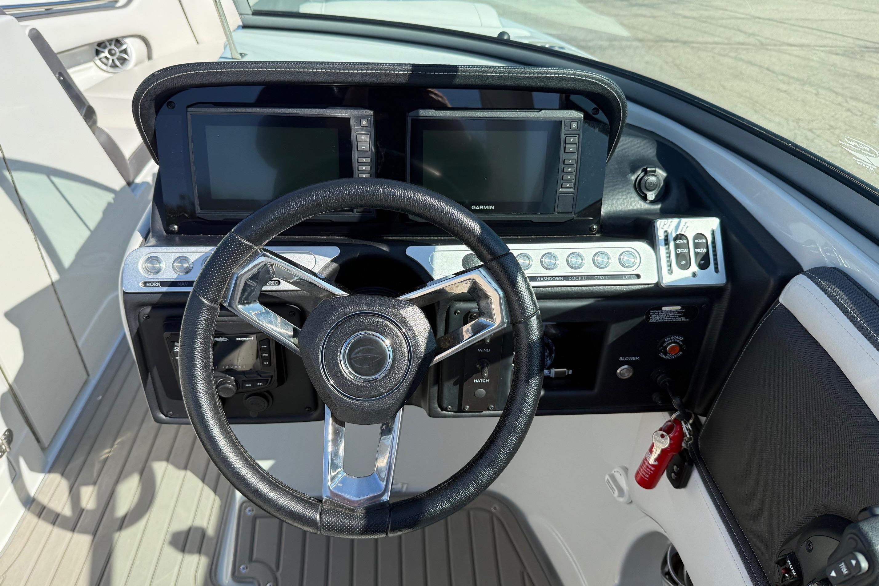2023 Crownline 290 SS boat dashboard with dual Garmin displays and steering wheel.
