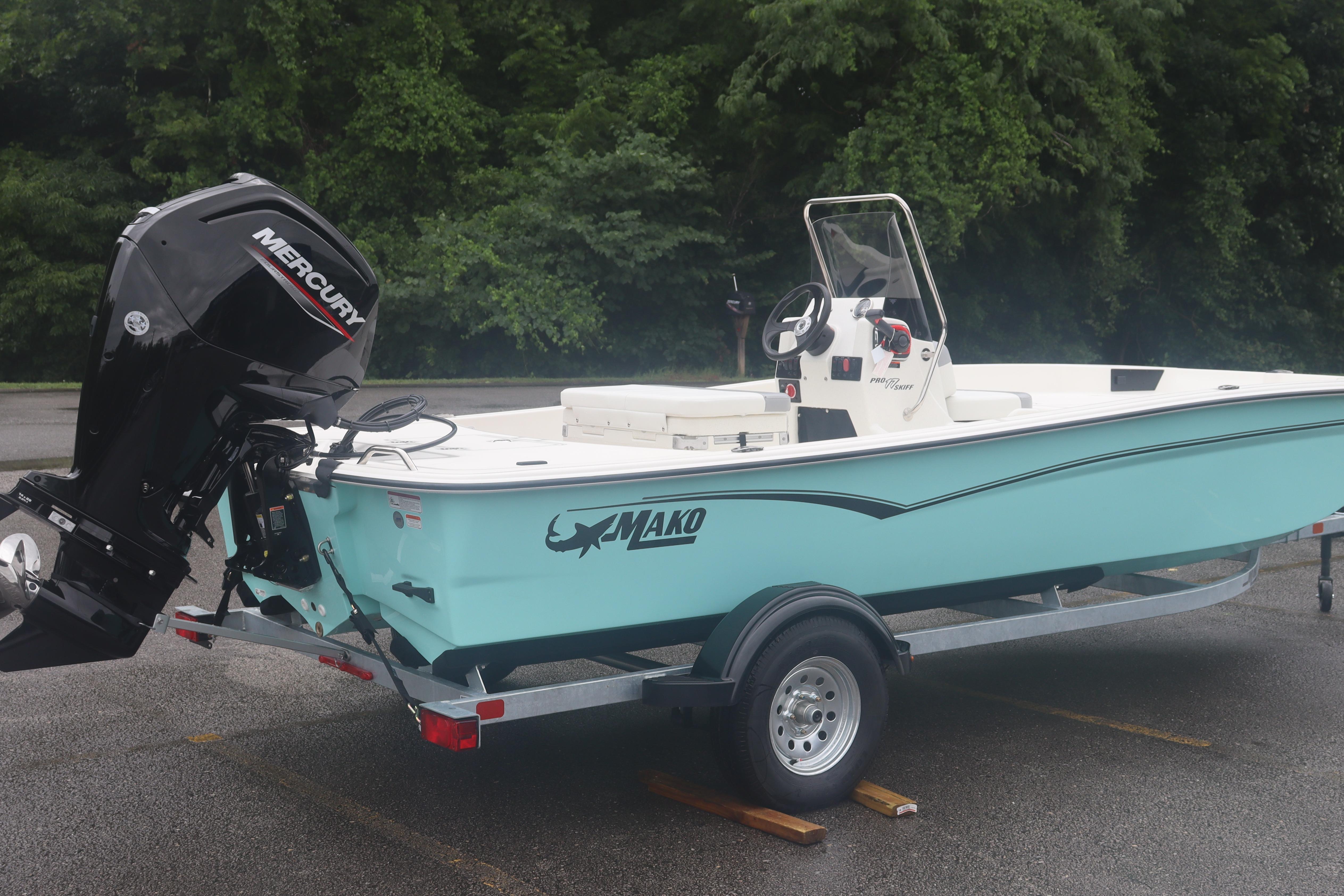 2026 Mako Pro Skiff 17 CC boat with Mercury engine on trailer, parked outdoors.