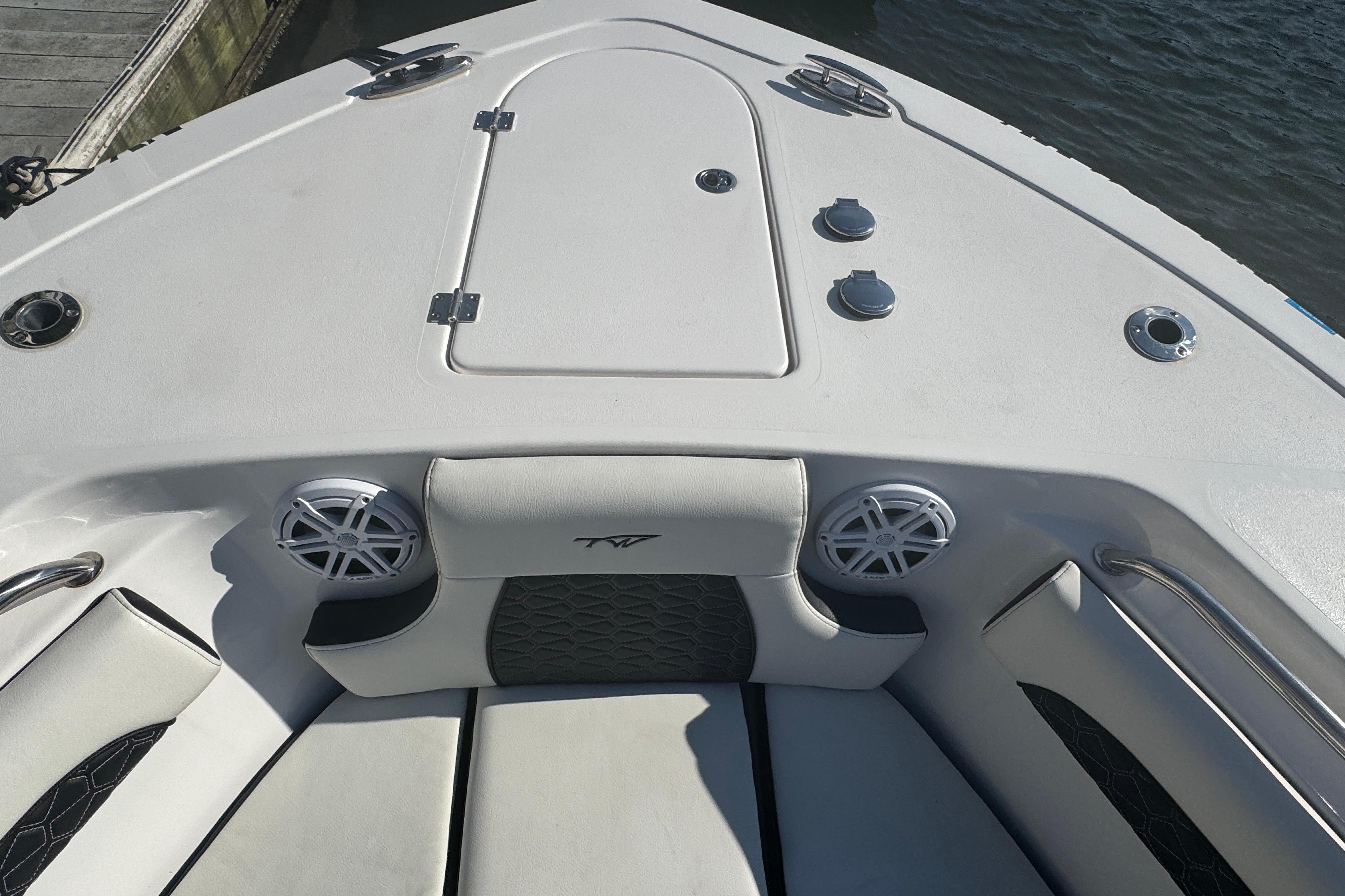 2025 Tidewater 232 LXF boat interior with cushioned seating and speakers.