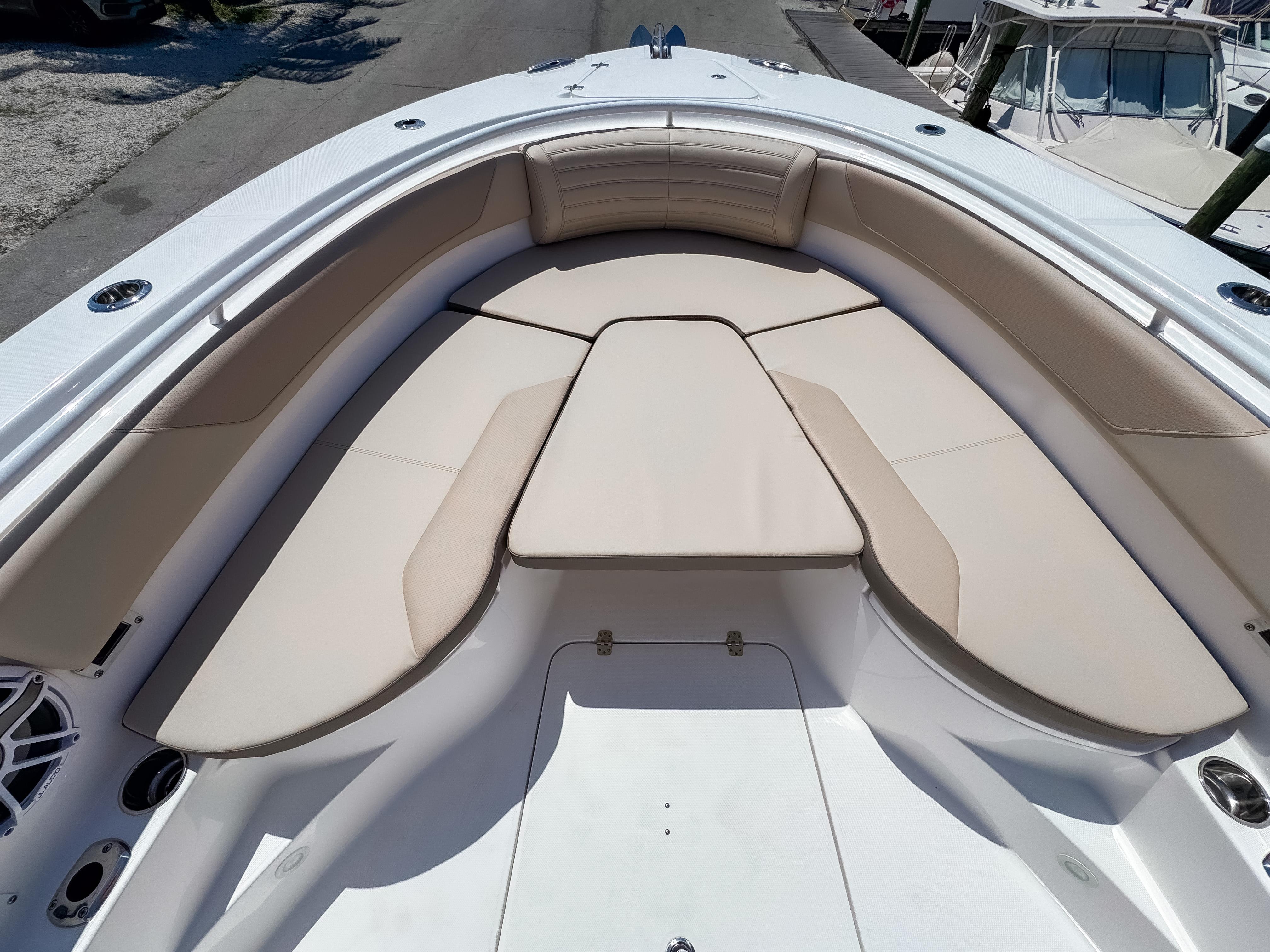 2025 Edgewater 325CC boat with spacious, cushioned seating area in the bow.