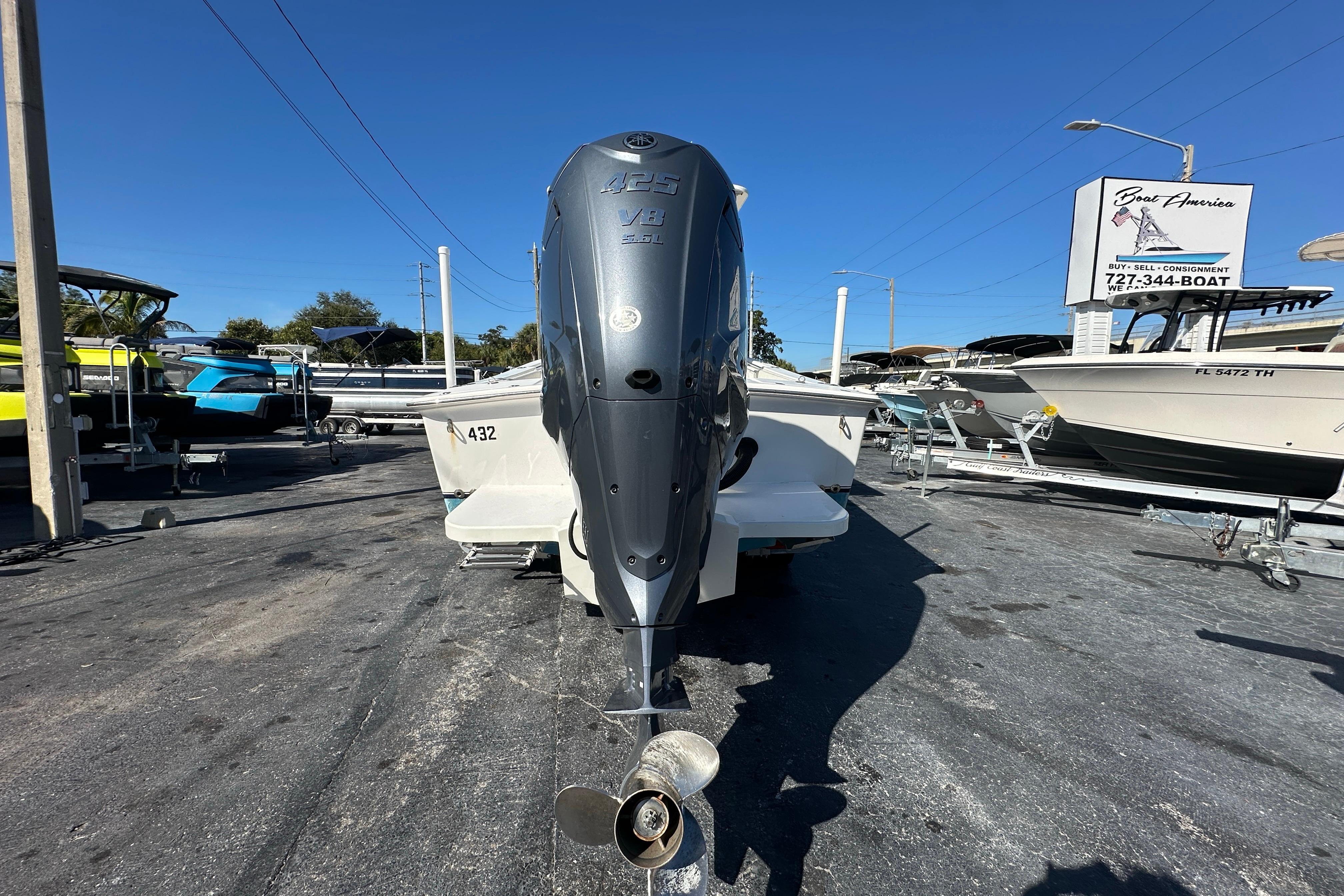 2005 Topaz 24 Silverhawk boat with powerful outboard motor in a dealership lot.