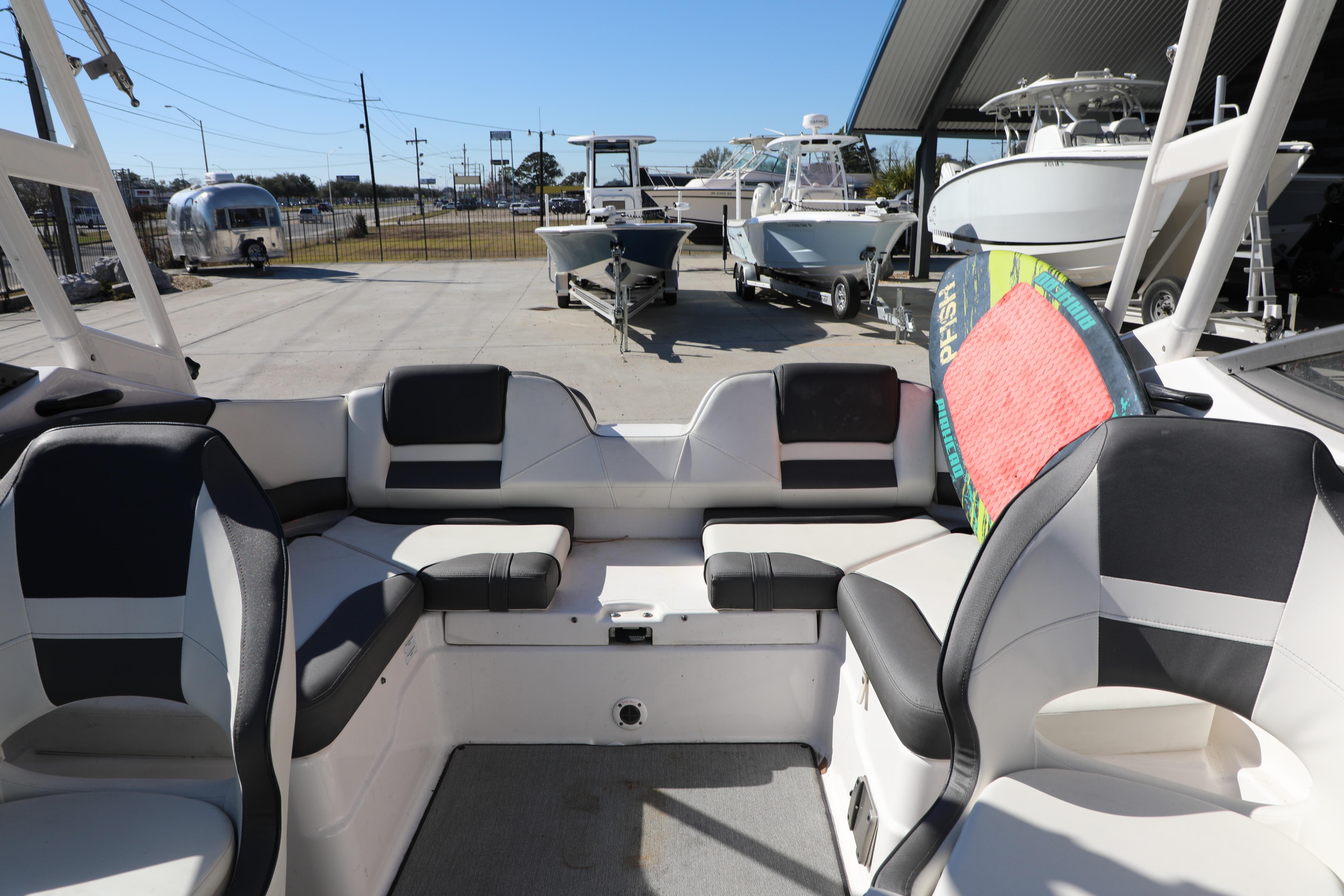 2022 Yamaha Boats AR210 interior with seating and a colorful wakeboard.
