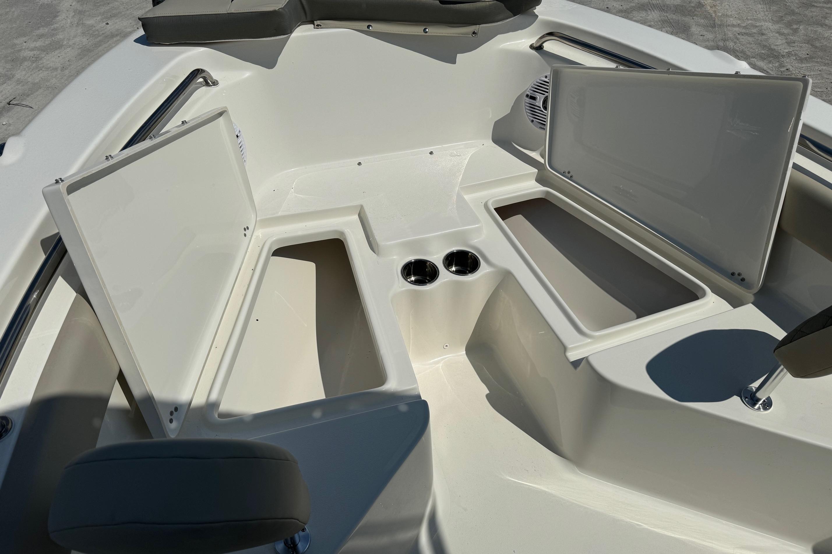 2025 Key West 203 FS boat interior with open storage compartments and cup holders.