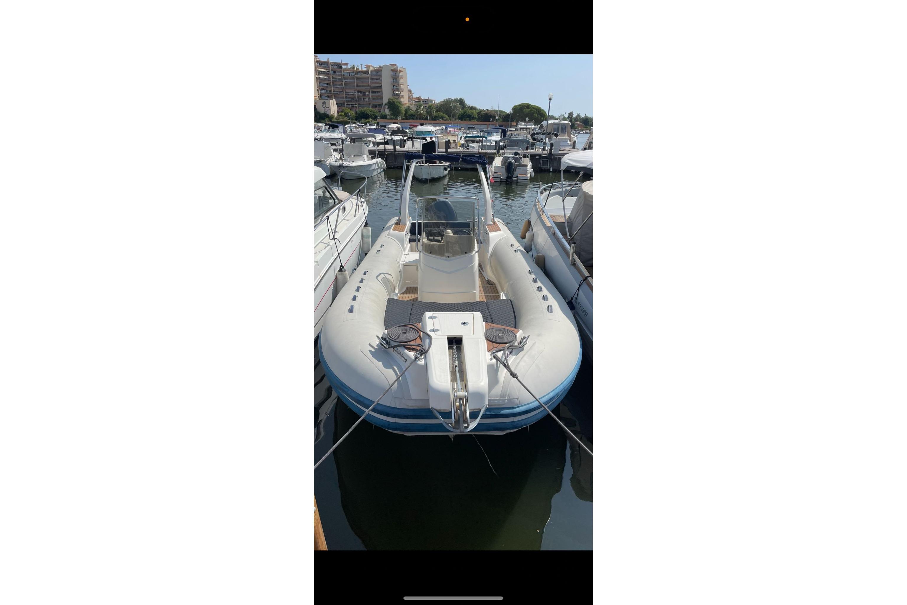 2020 Capelli Tempest 775 boat docked in a marina, surrounded by other vessels.