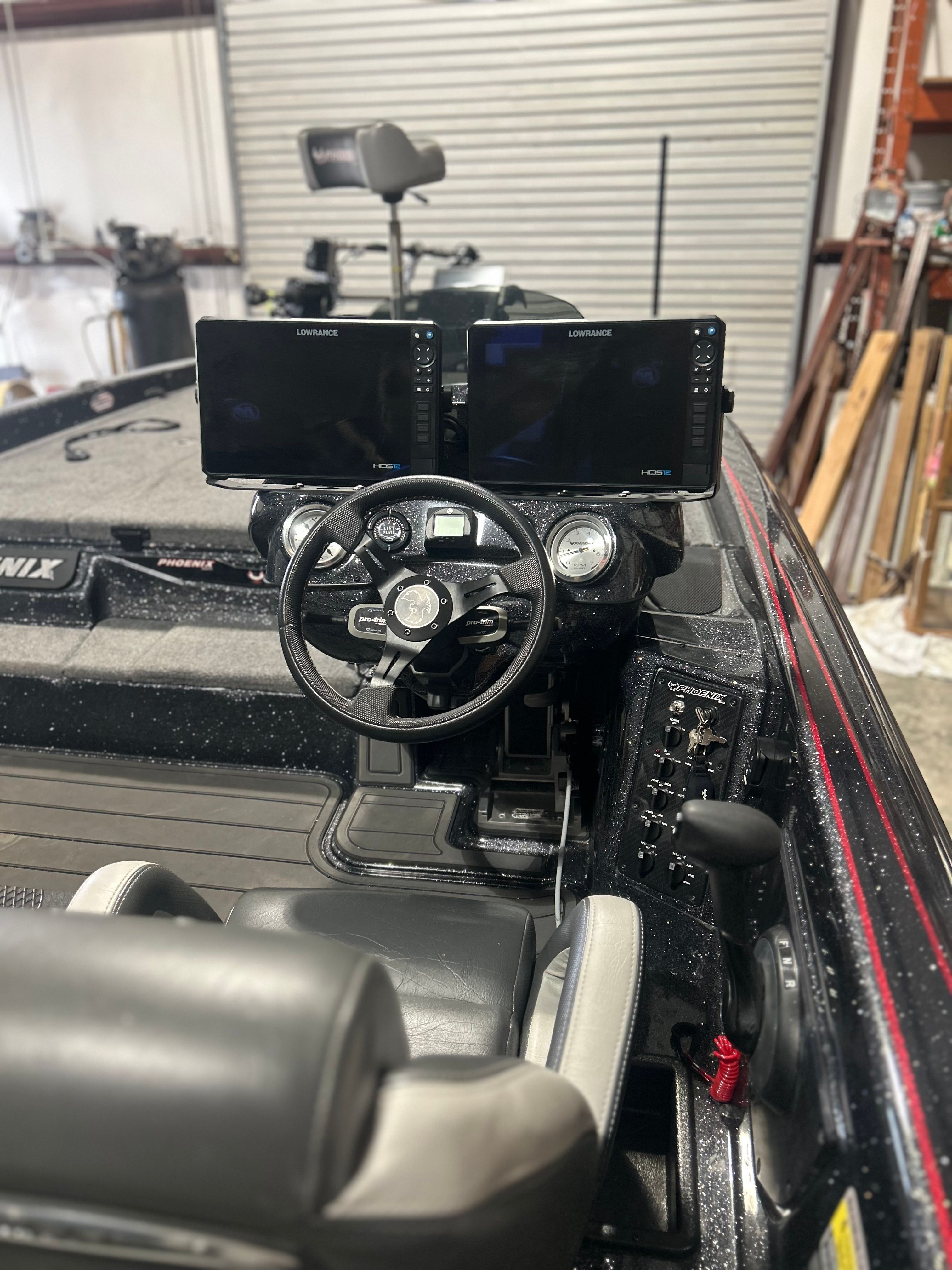 The image shows the cockpit of a Phoenix 921 Elite boat with two large screens.