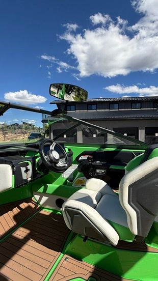 The green interior of a 2018 Nautique Super Air Nautique G23 with modern steering wheel and seats.