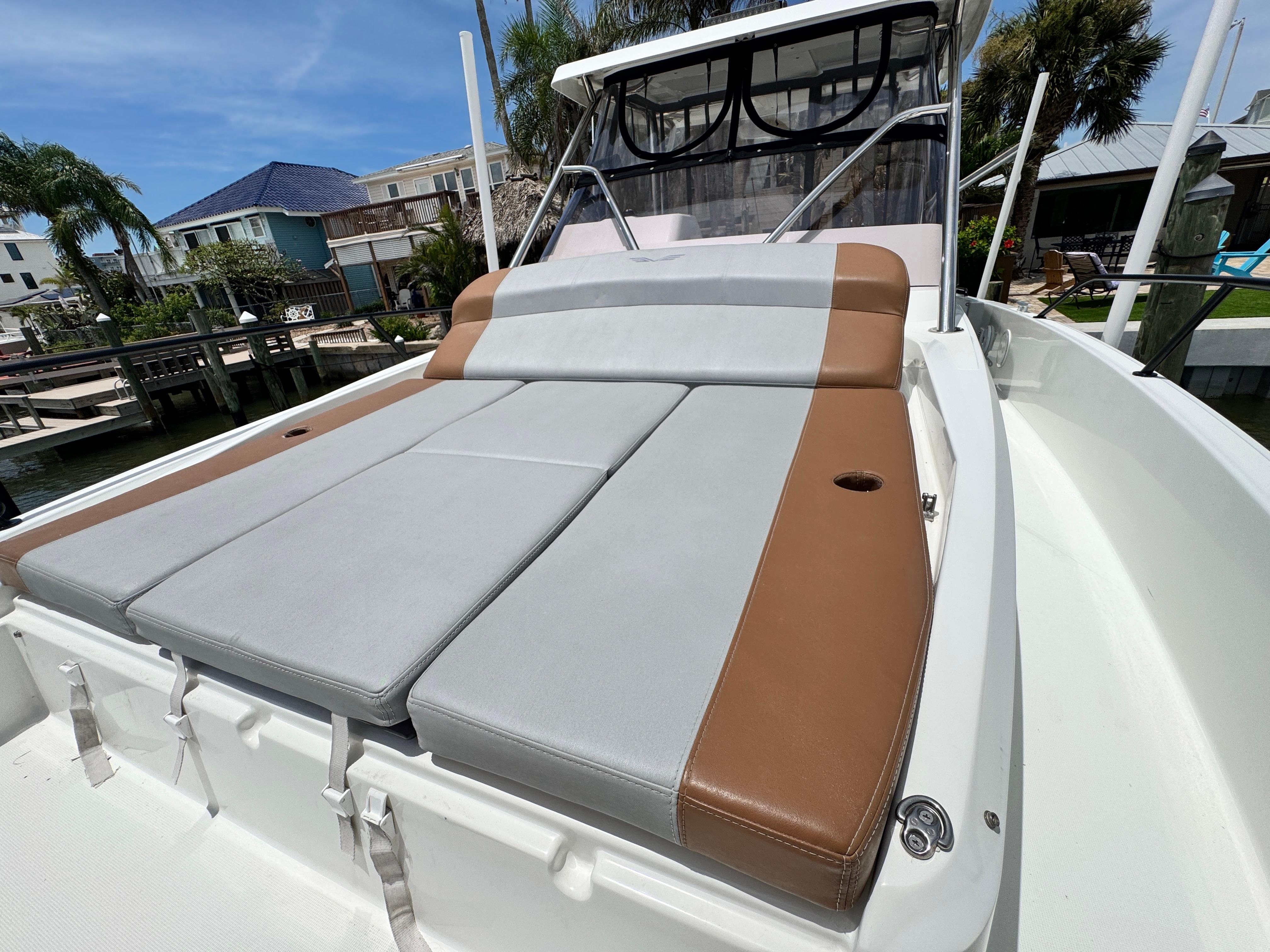 2022 Beneteau Flyer 9 SUNdeck with cushioned sunbathing area, docked near waterfront homes.