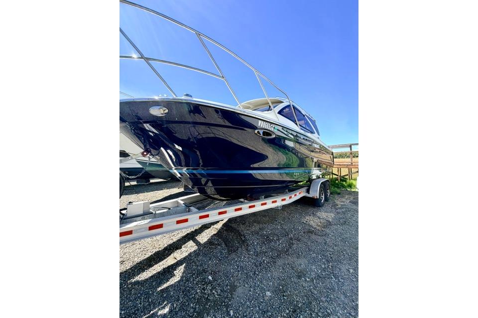 2017 Cutwater C-242 Coupe boat on trailer under clear blue sky.