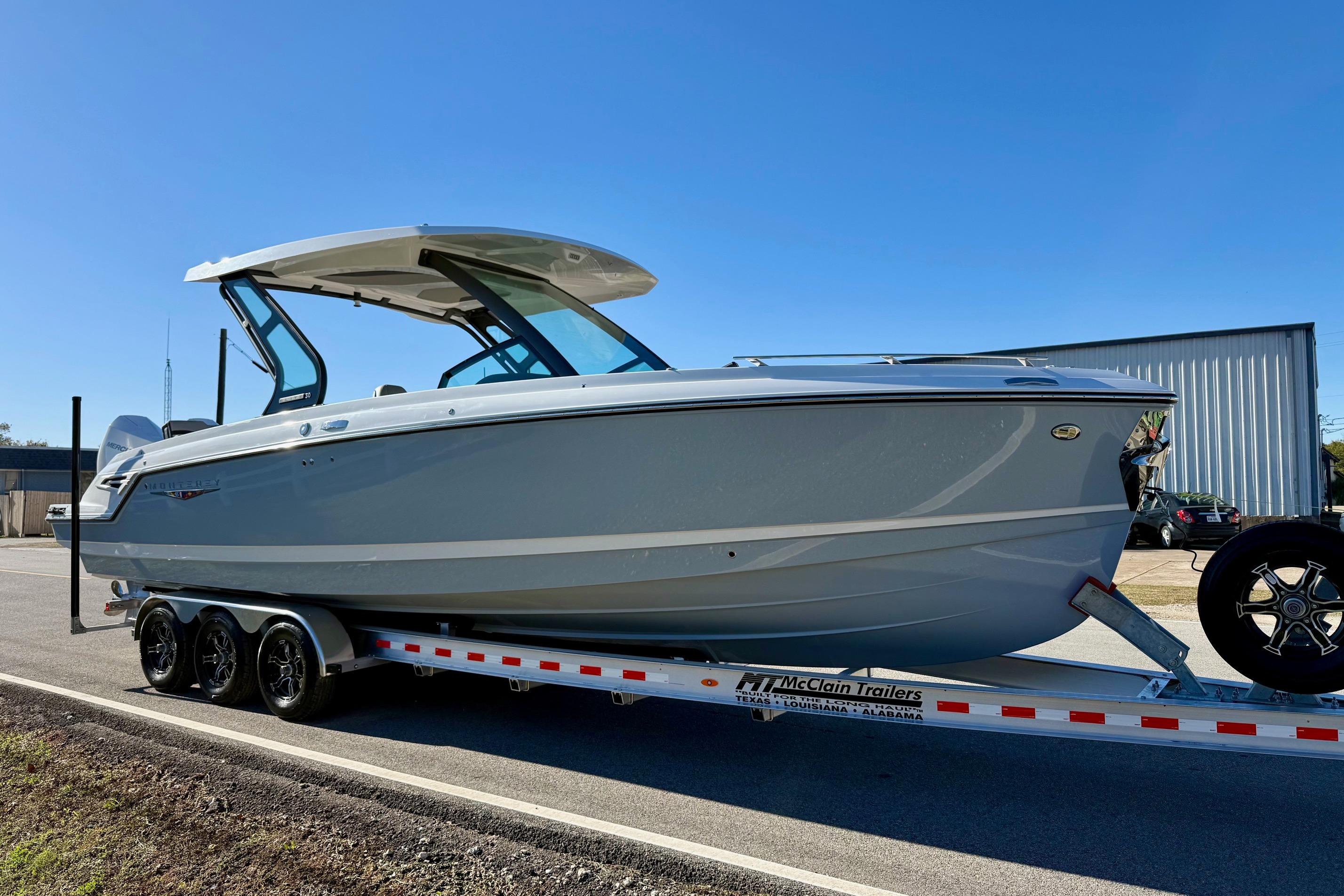 2026 Monterey Elite 30 OB boat on trailer in sunny weather.