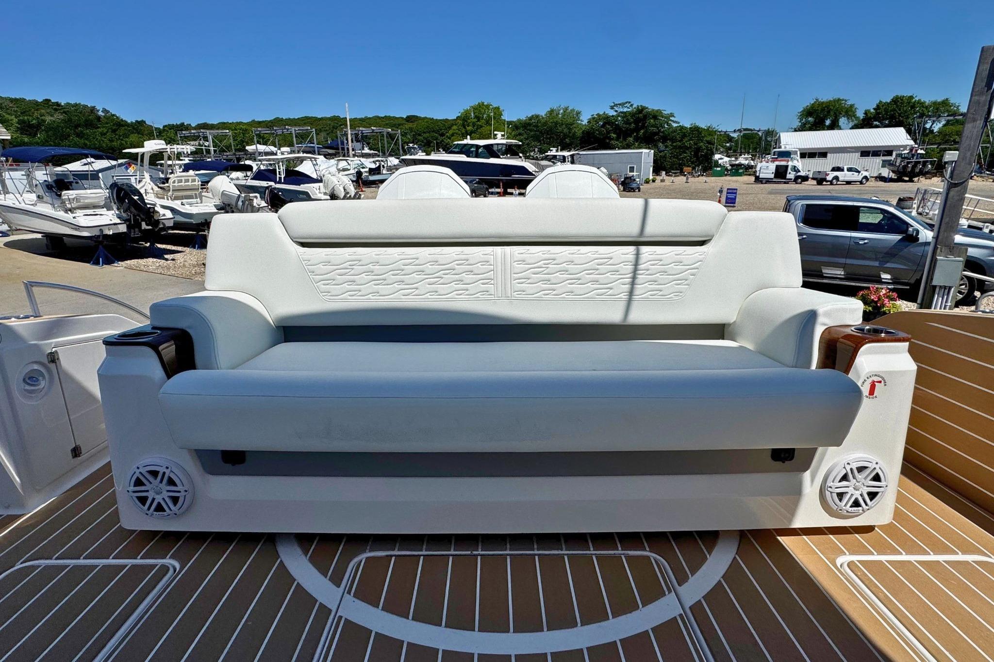2027 Tiara Yachts 39 LE luxury seating on deck, surrounded by boats and vehicles.