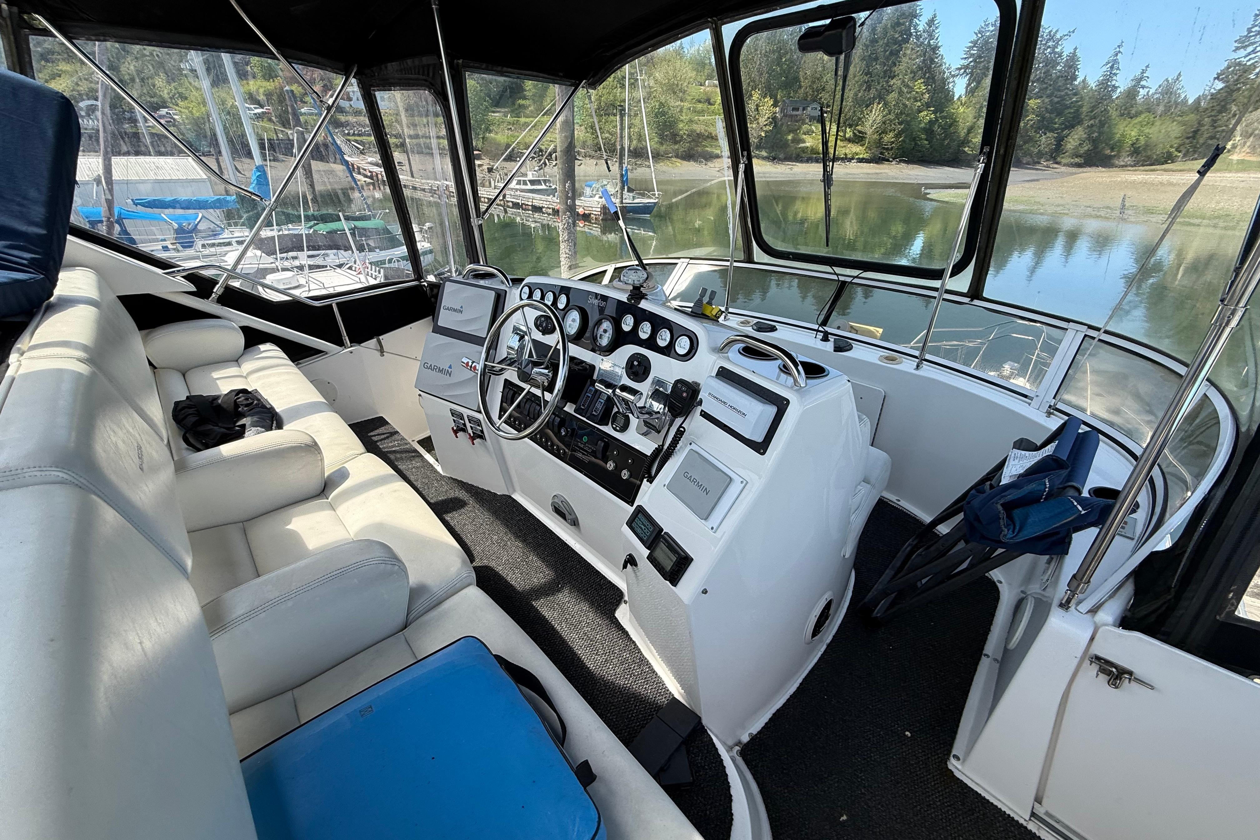 Interior view of 1998 Silverton 372 Motor Yacht cockpit with steering wheel and seating.