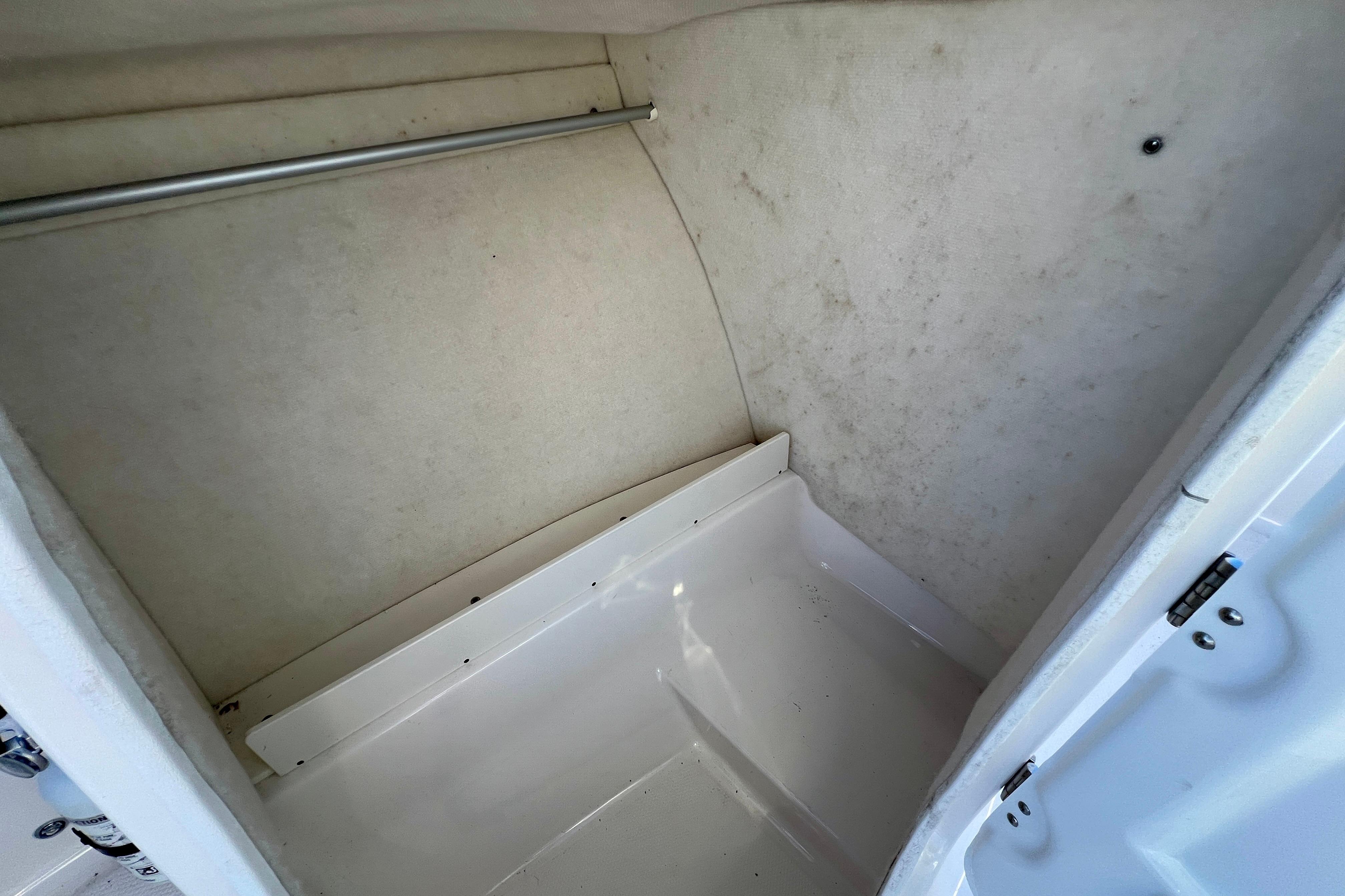 2024 Robalo R207 Dual Console interior storage compartment, featuring clean white surfaces and a metal rod.