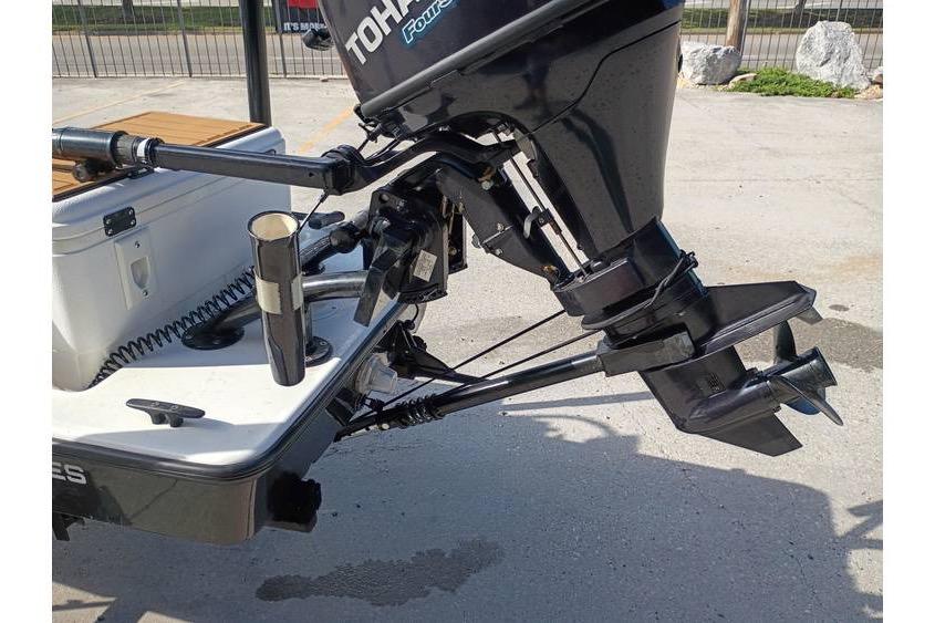 2013 Pelican Ambush boat with Tohatsu outboard motor, docked on concrete surface.