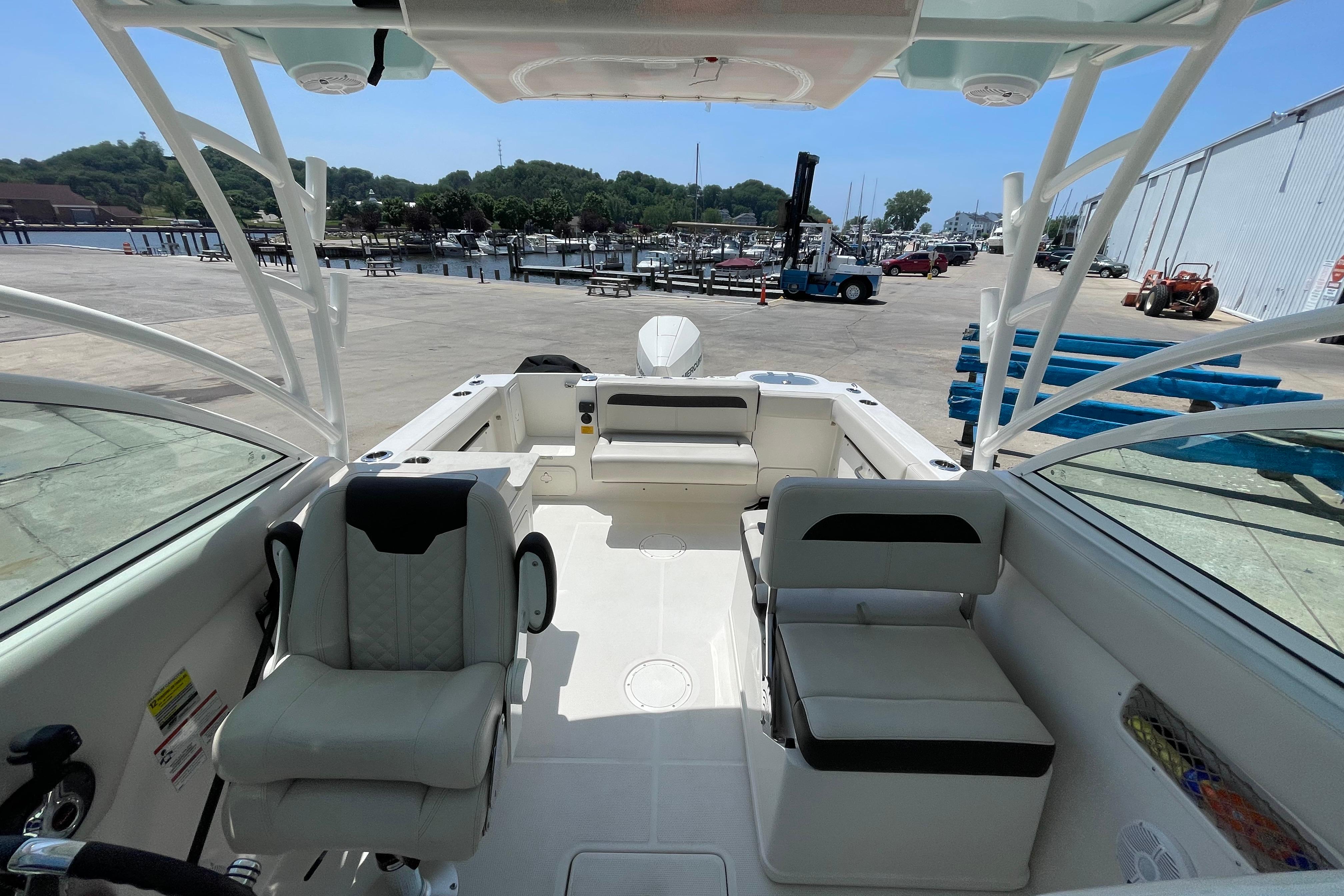 2022 Sailfish 245 DC boat interior at marina, featuring seating and helm.