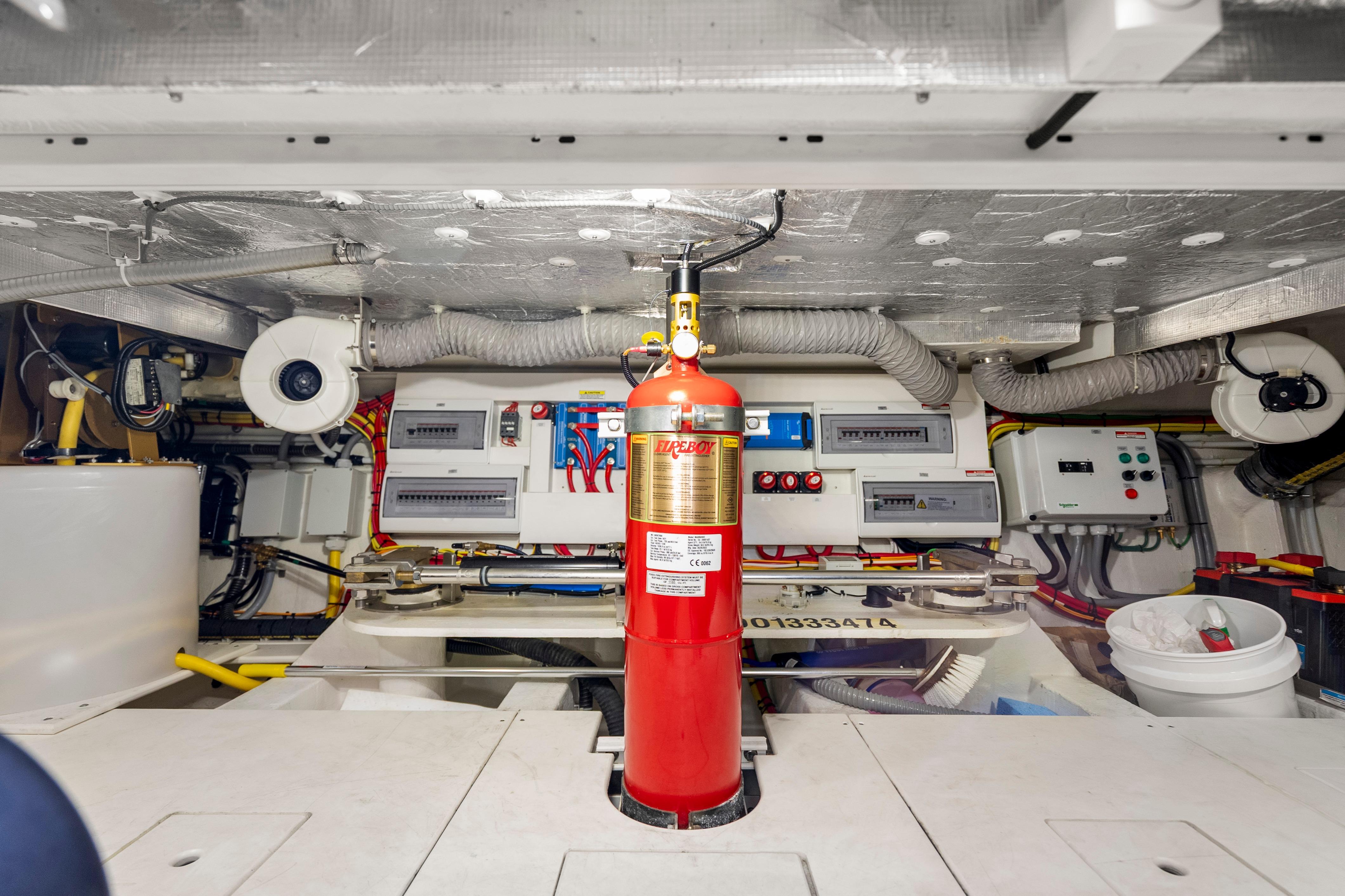 Engine room of 2023 Galeon 400 Fly yacht with fire extinguisher and control panels.