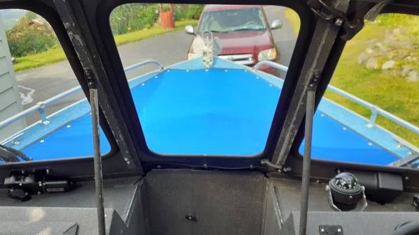 View from inside a boat with a blue deck and windows.