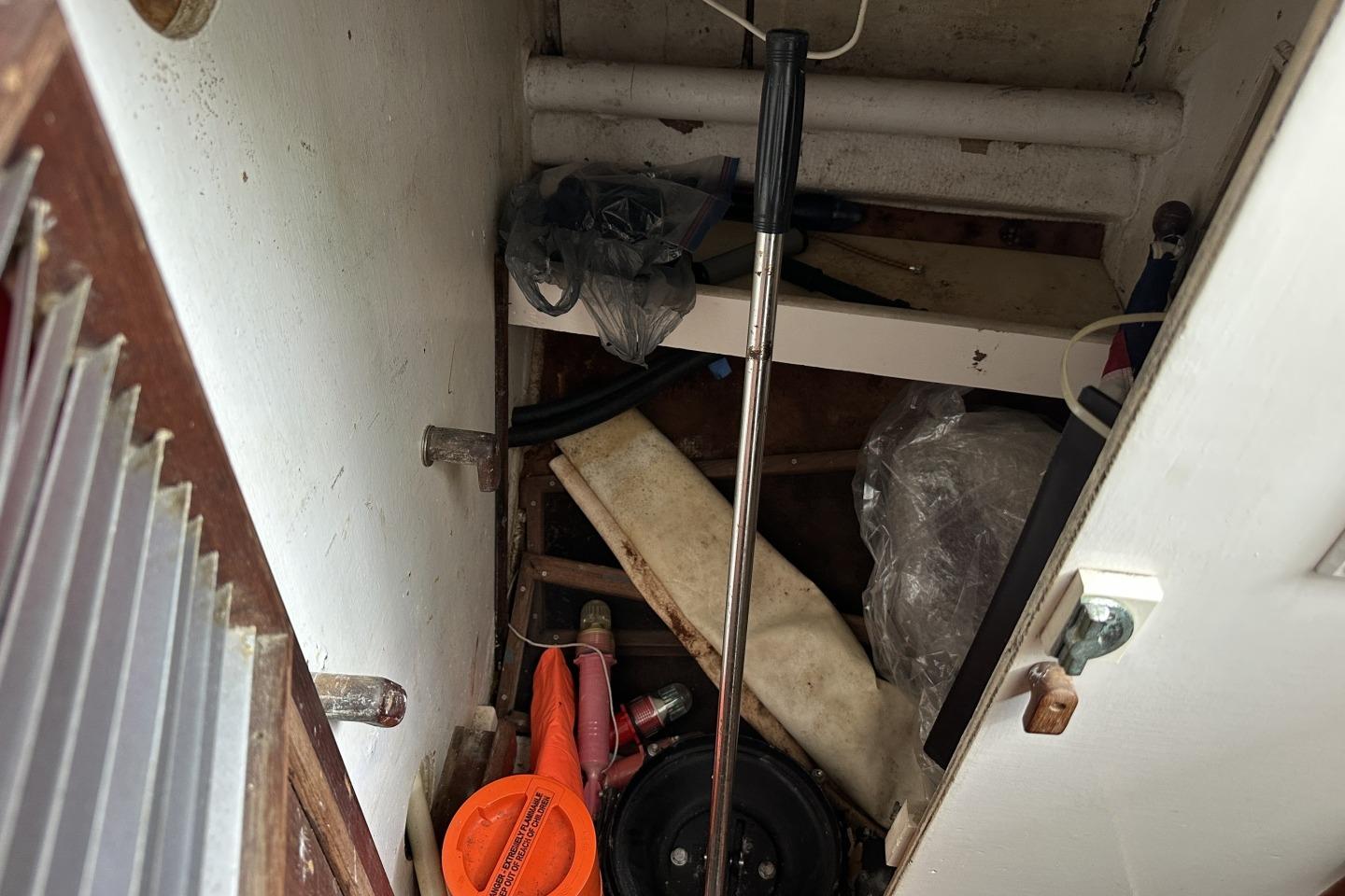 Storage compartment in a 1976 Valiant 40 boat with various tools and equipment.