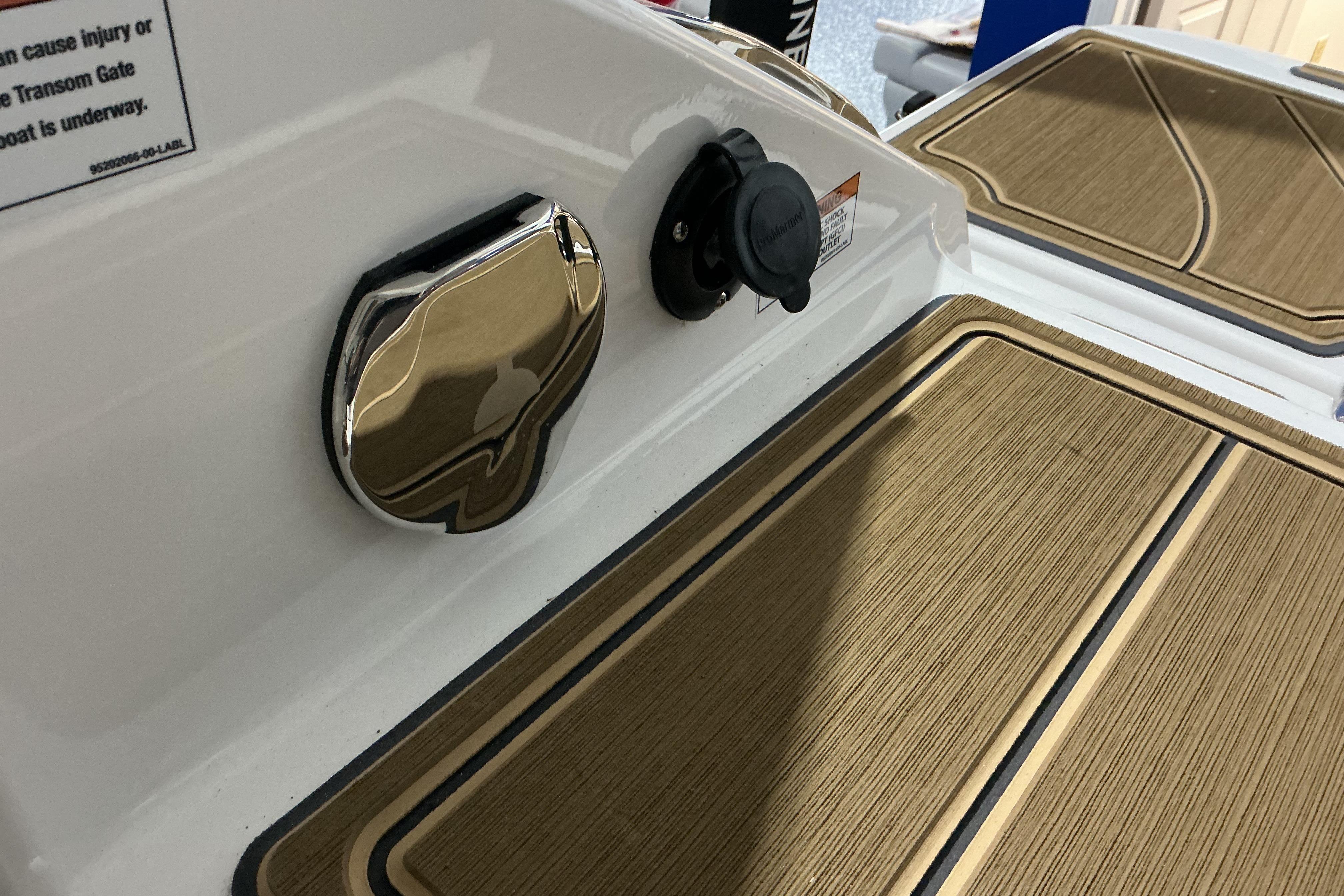 2026 Monterey Elite 25 OB boat deck with wood finish and chrome details.