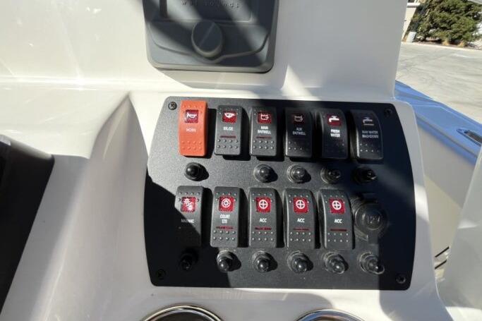 Control panel of a 2025 Mako 214 Center Console boat with labeled switches.