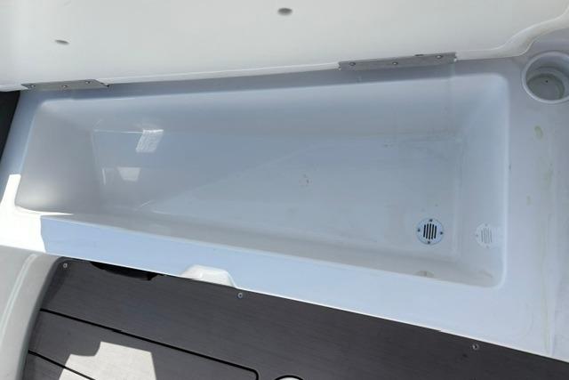 2024 Tahoe T21 boat storage compartment with drainage system, featuring sleek white interior design.