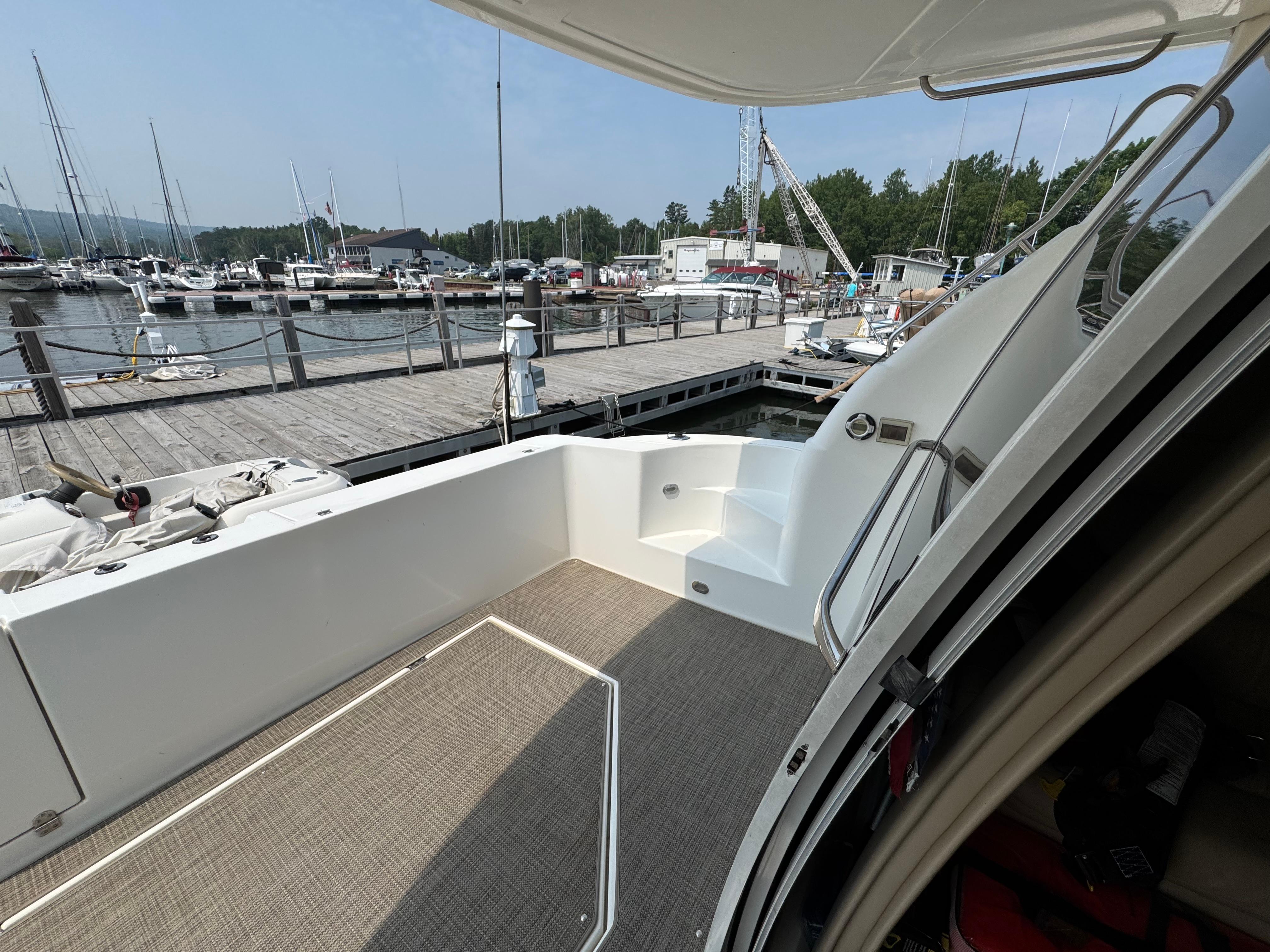 2003 Cruisers Yachts 5000 Sedan Sport docked at marina, showing deck and stairs.