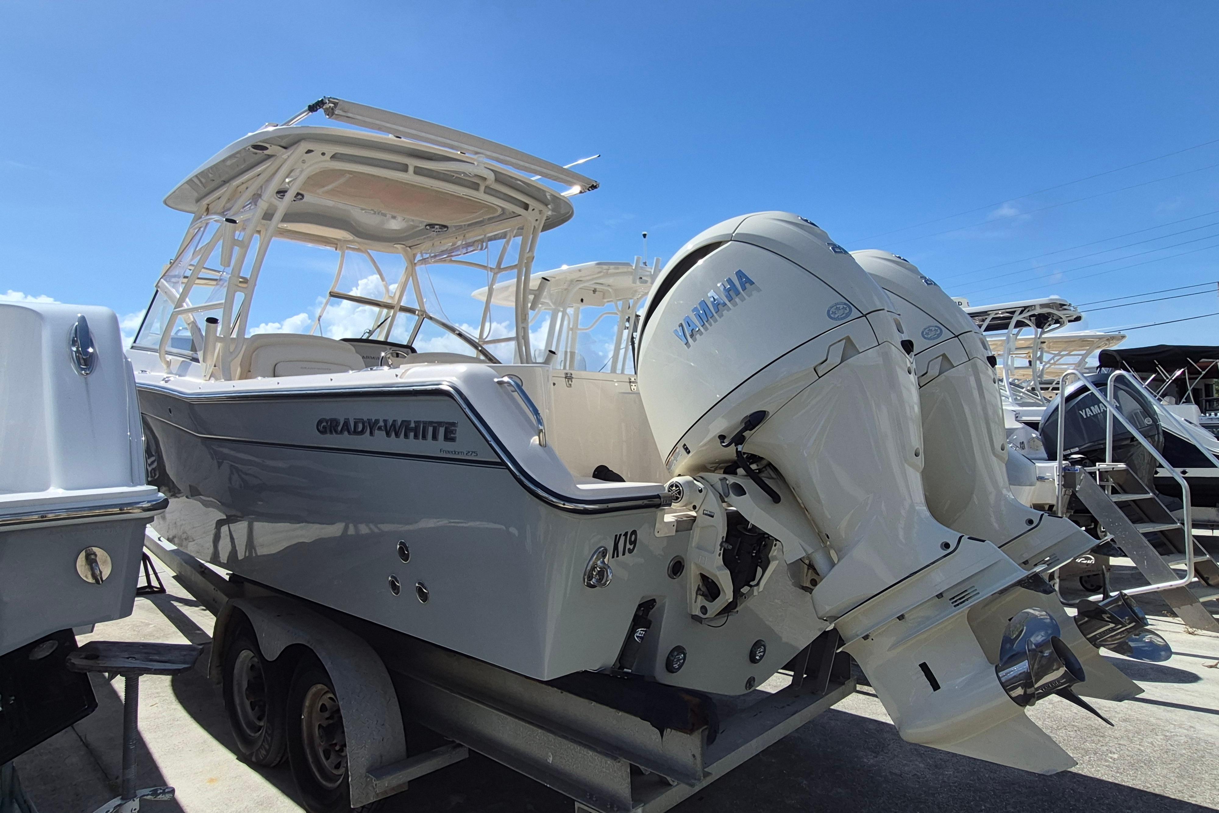 2025 Grady-White Freedom 275 boat with Yamaha engines on a trailer under clear blue sky.