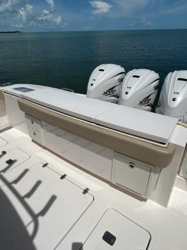 2019 Pursuit S 408 Sport boat with triple outboard engines on calm water.